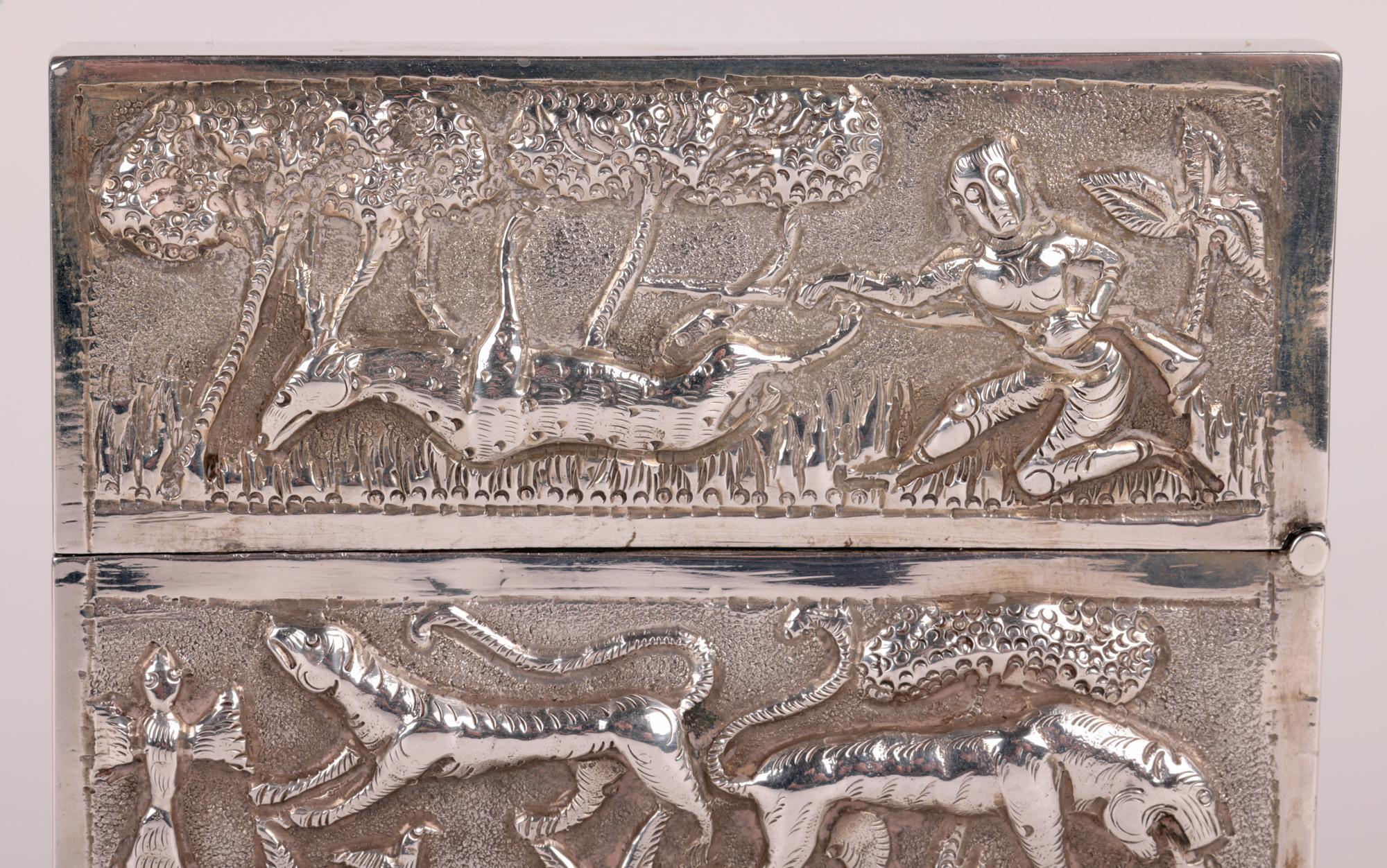 A fine quality and heavily made antique Indian silver card case decorated in repoussé with animals and other scenes probably dating from the early 20th century. The card case is of flat rectangular shape with a piano hinged cover with a shaped