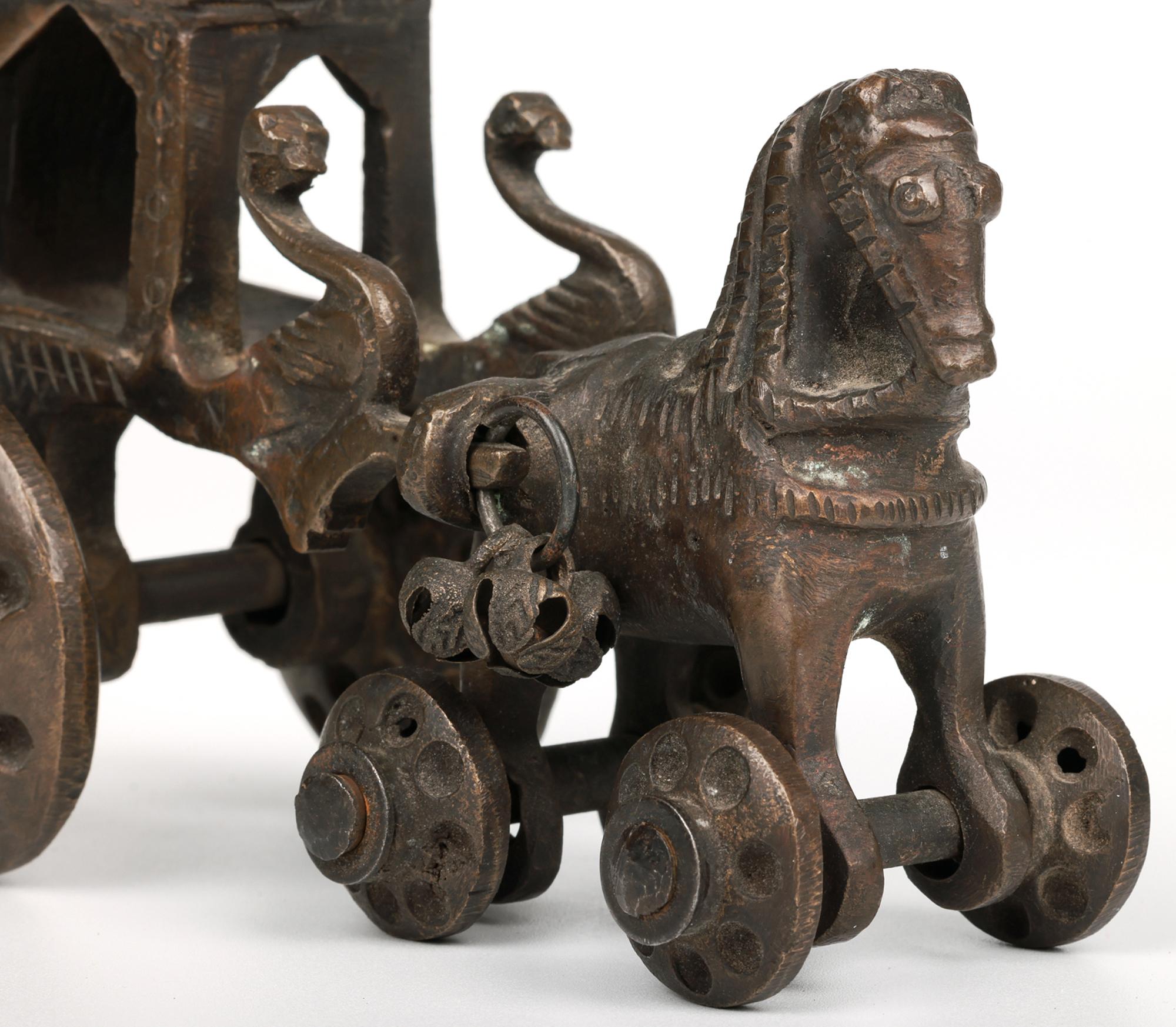 A delightful antique Indian Hindu bronze toy modelled as a horse drawn chariot mounted on wheels and dating from the 19th century. The heavily made model is cast as a four-legged horse mounted on wheels with supports to either side of the rear body