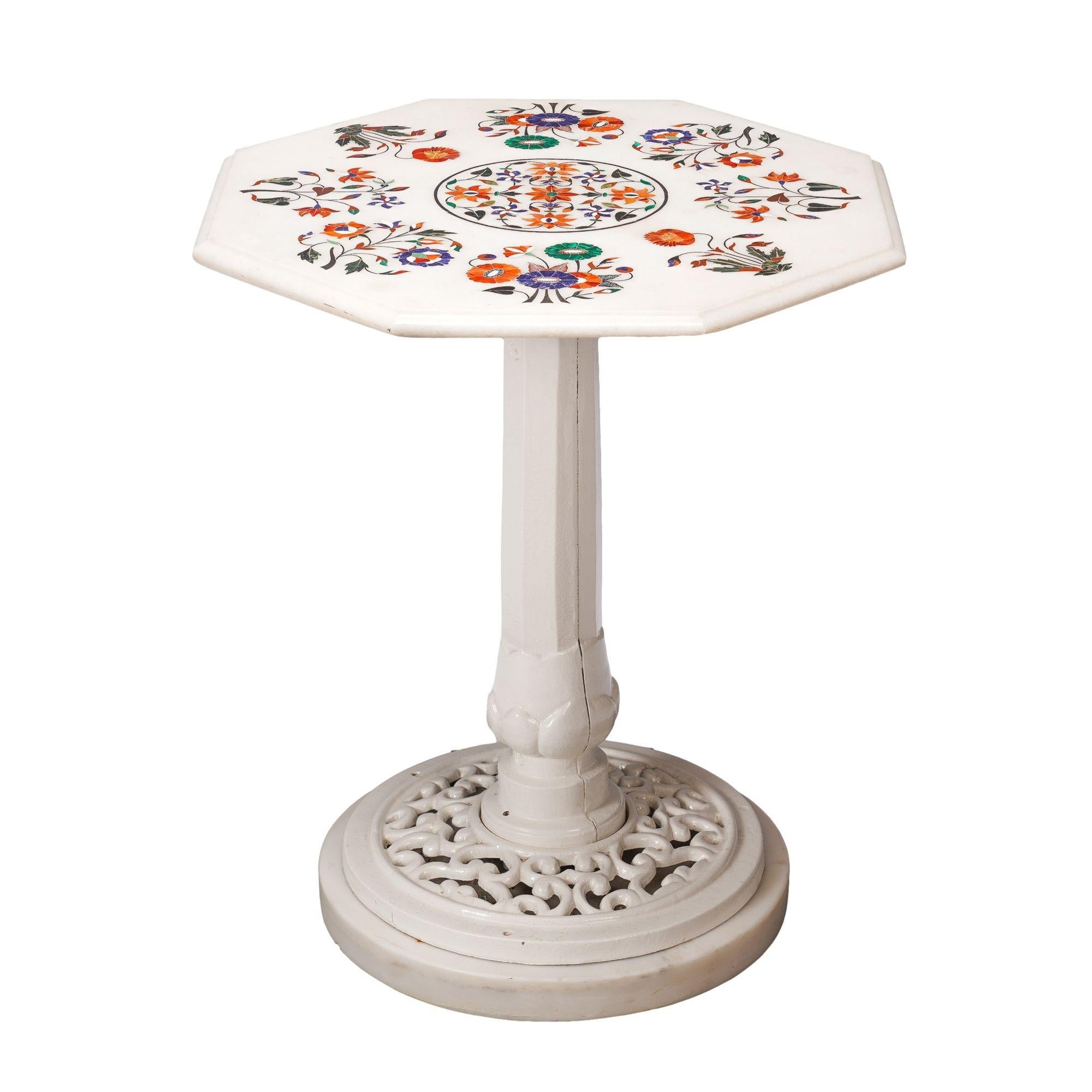 Tablero octogonal de mármol blanco con incrustaciones de cornalina, malaquita y lapislázuli en diseños arabescos clásicos de Agra. La encimera de mármol está montada en un pedestal de hierro fundido pintado del siglo XIX sobre una base de mármol