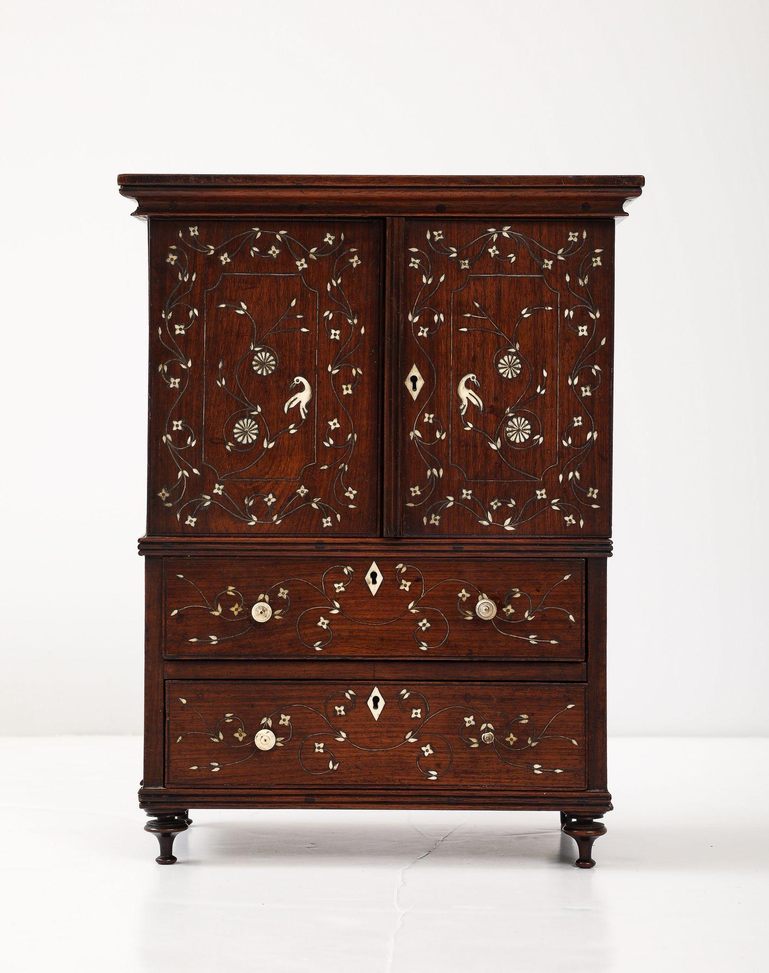 Fine early 19th Century Indian bone inlaid padouk miniature secretary, Monghyr, the two doors inlaid with flowers, vines and birds opening to reveal a fall front writing surface, the reverse side of the doors fitted with pigeonholes with scalloped