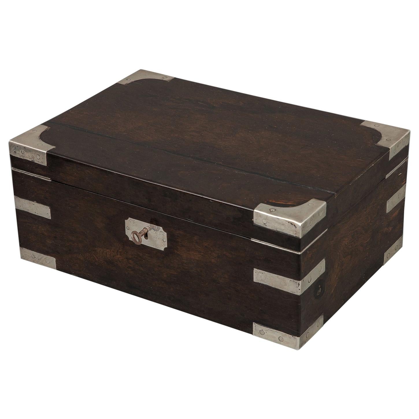 A very stylish box of superior quality with two removable red velvet lined trays this box was probably a ladies jewelry box or a gentleman’s box for accoutrements. The rich depth of color to the wood is set of with well-placed silver enhancements