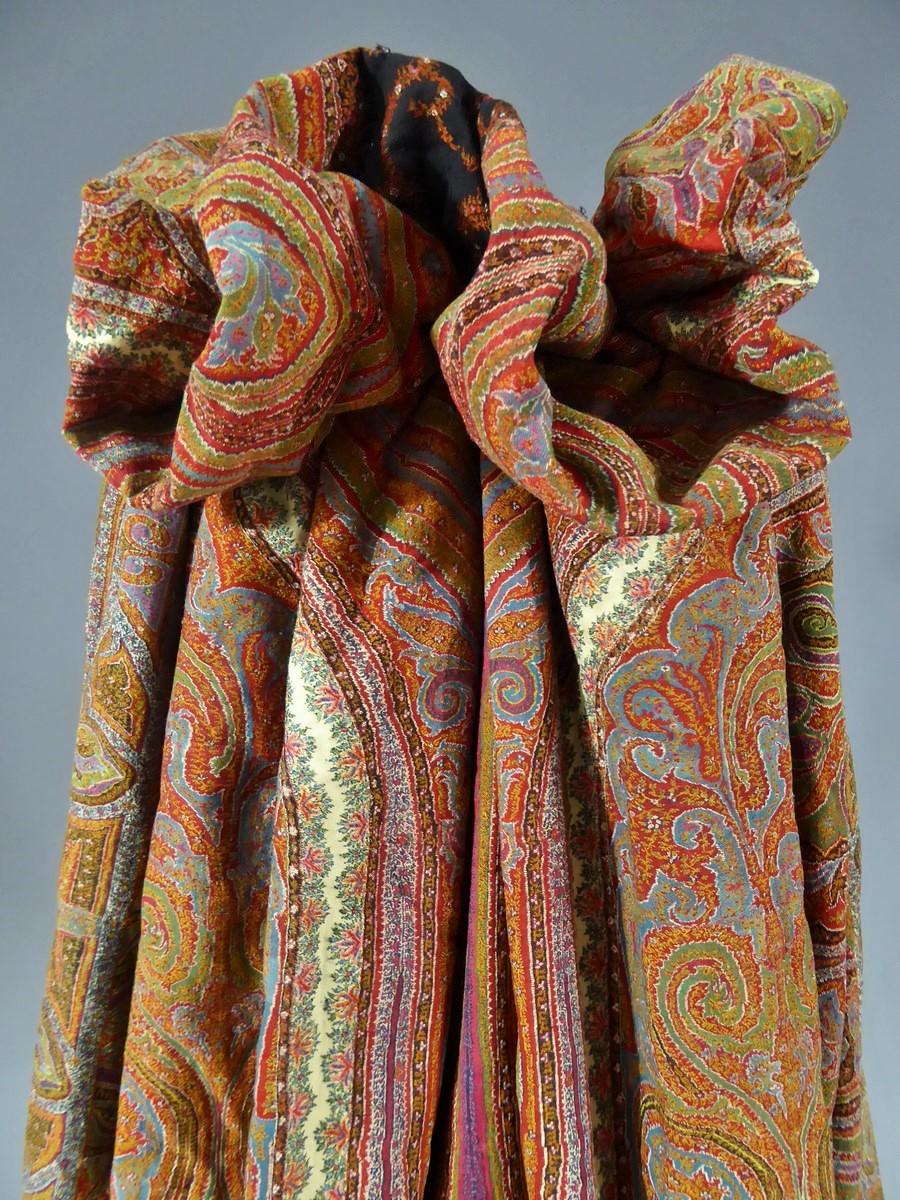 Circa 1860/1875

France

An astonishing cashmere cloak coat from the Indies dating from the end of the Second French Empire. Finely kani Indian cashmere in a strong polychromy (9 colors) of interlacing and palms in a cashmere pattern. Embroidered