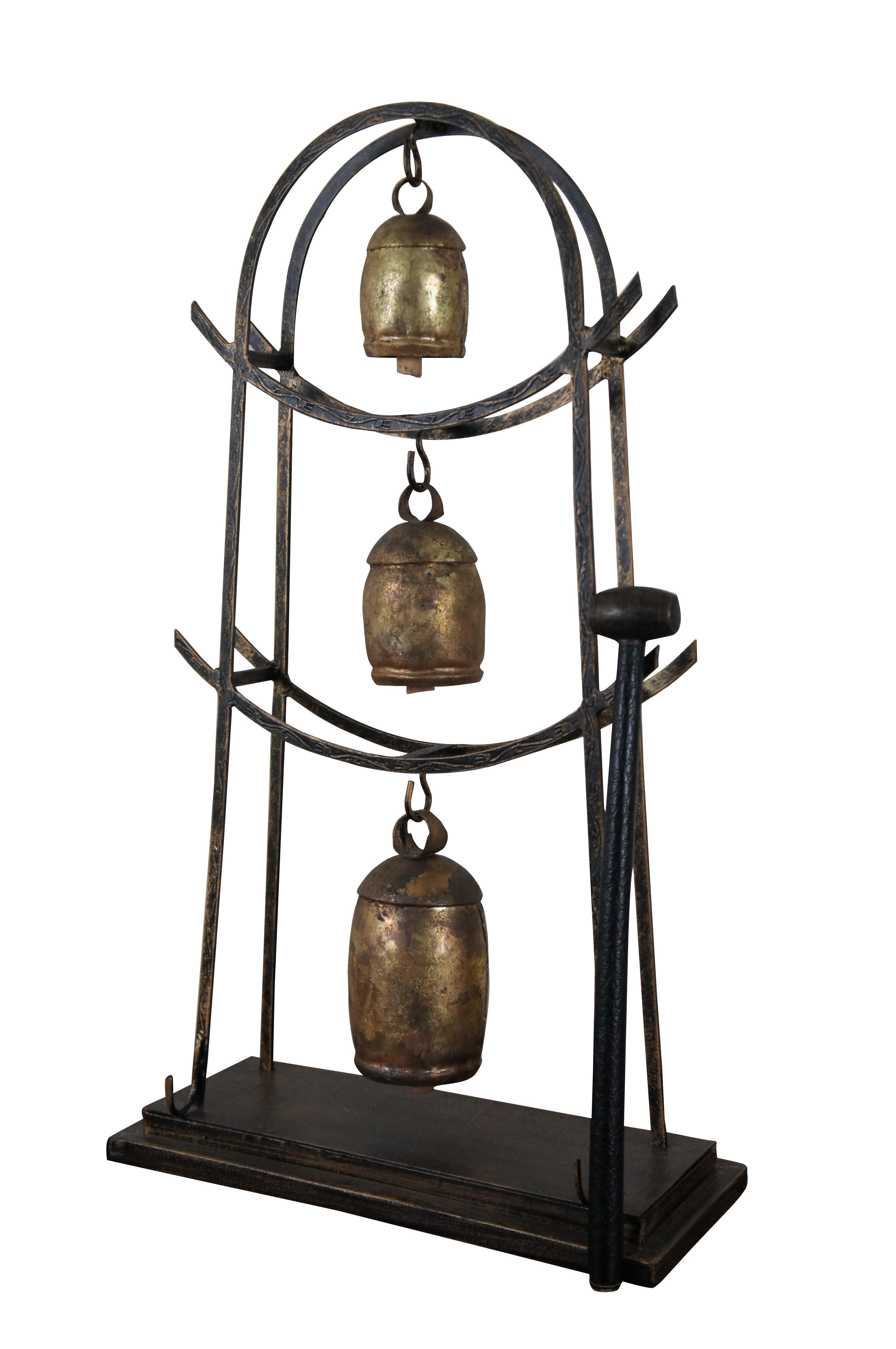 Vintage set of three Indian “Noah” or temple bells, handmade in iron and brass with wooden clappers, suspended from tiers of an arched metal frame. Base includes hooks for holding the long wooden mallet with leather wrapped handle.

Noah Bell