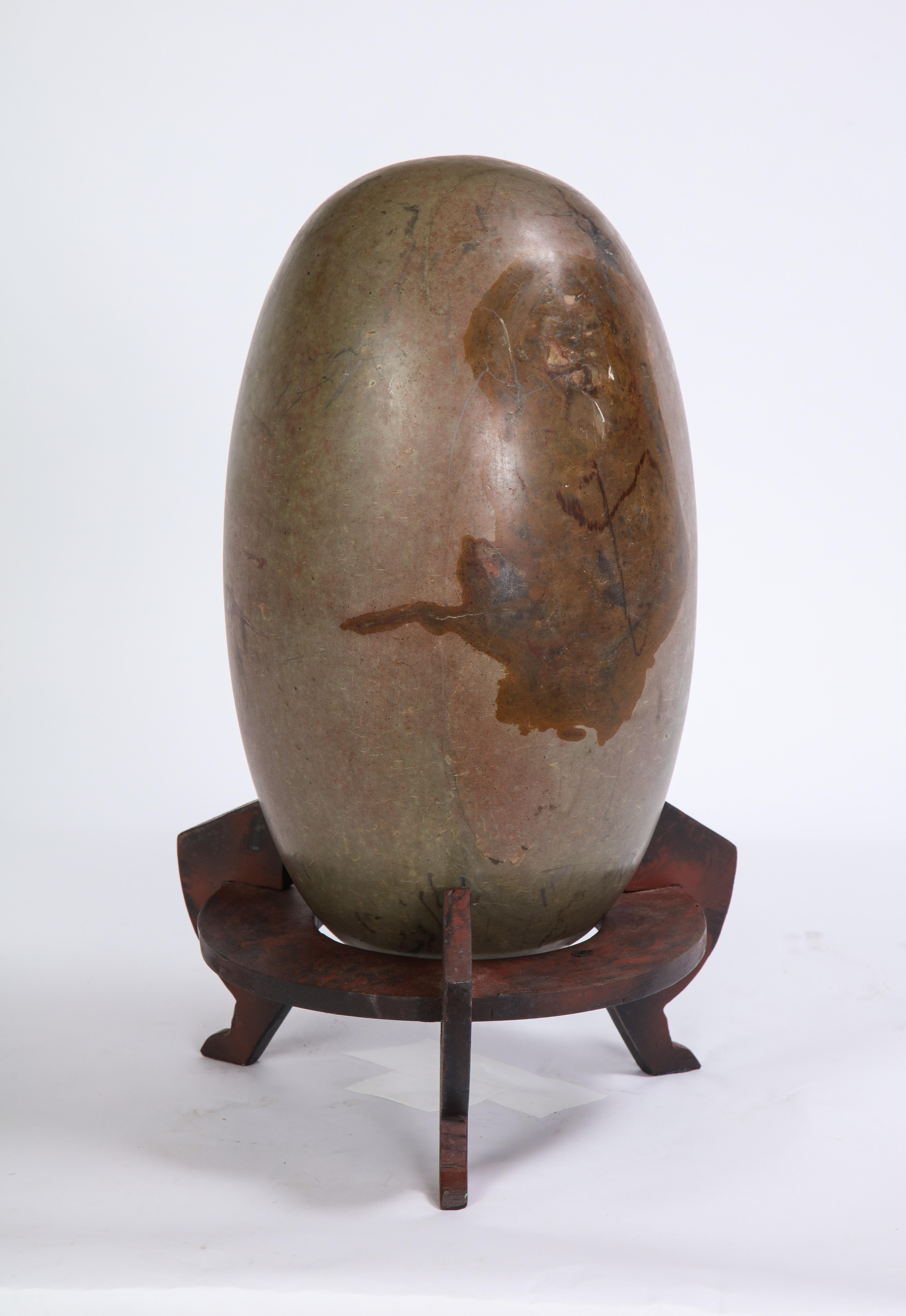 This dark gray lignum stone was sourced as part of a group of three by Juan Montoya in India. He commissioned the steel stands based on a design by Marc du Plantier - one for each of the three stones he found. Historically, lignum stones are