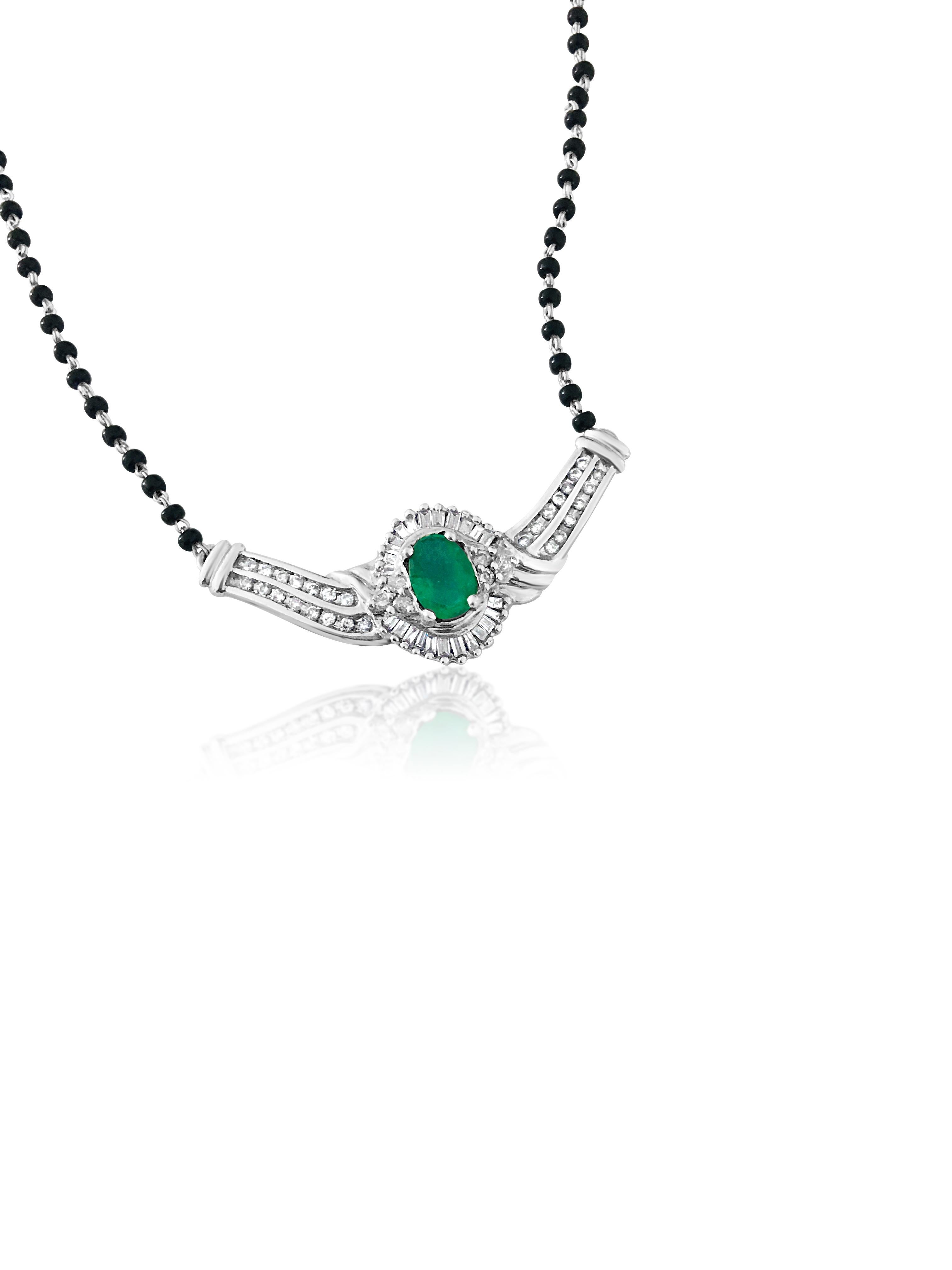 This exquisite necklace boasts a stunning 3.00 carat oval cut Colombian emerald, set elegantly in prongs crafted from 14k white gold. Adorned with a total of 1.10 carats of round brilliant cut and baguette cut diamonds, all meticulously set in