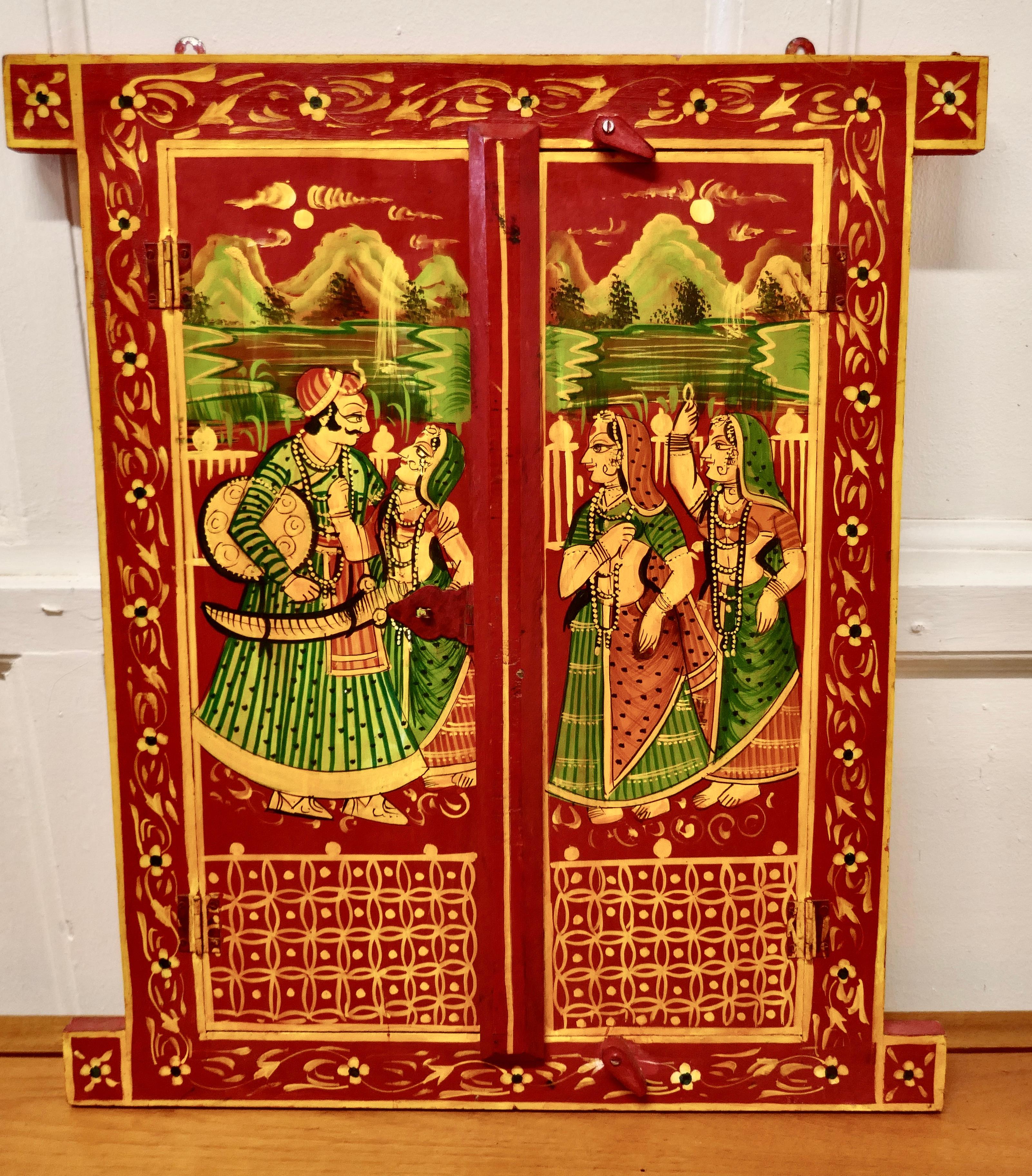Indian miniature doors, Folk Art shutters

These Beautiful framed doors are beautifully and brightly hand painted with Indian Characters in traditional dress.
The pair of doors have their original metal hinges and wooden closers. This is a most