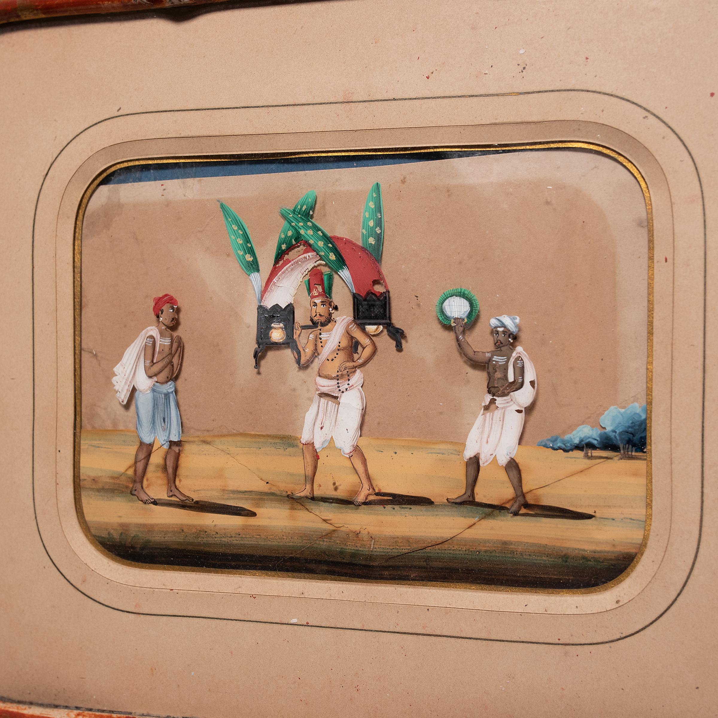 Made with gouache paint and encased in a charming bamboo frame, is this miniature Indian mica painting depicting village life in the 19th-century. Considered a novelty for the colonial tourist market, miniature mica paintings were commissioned by