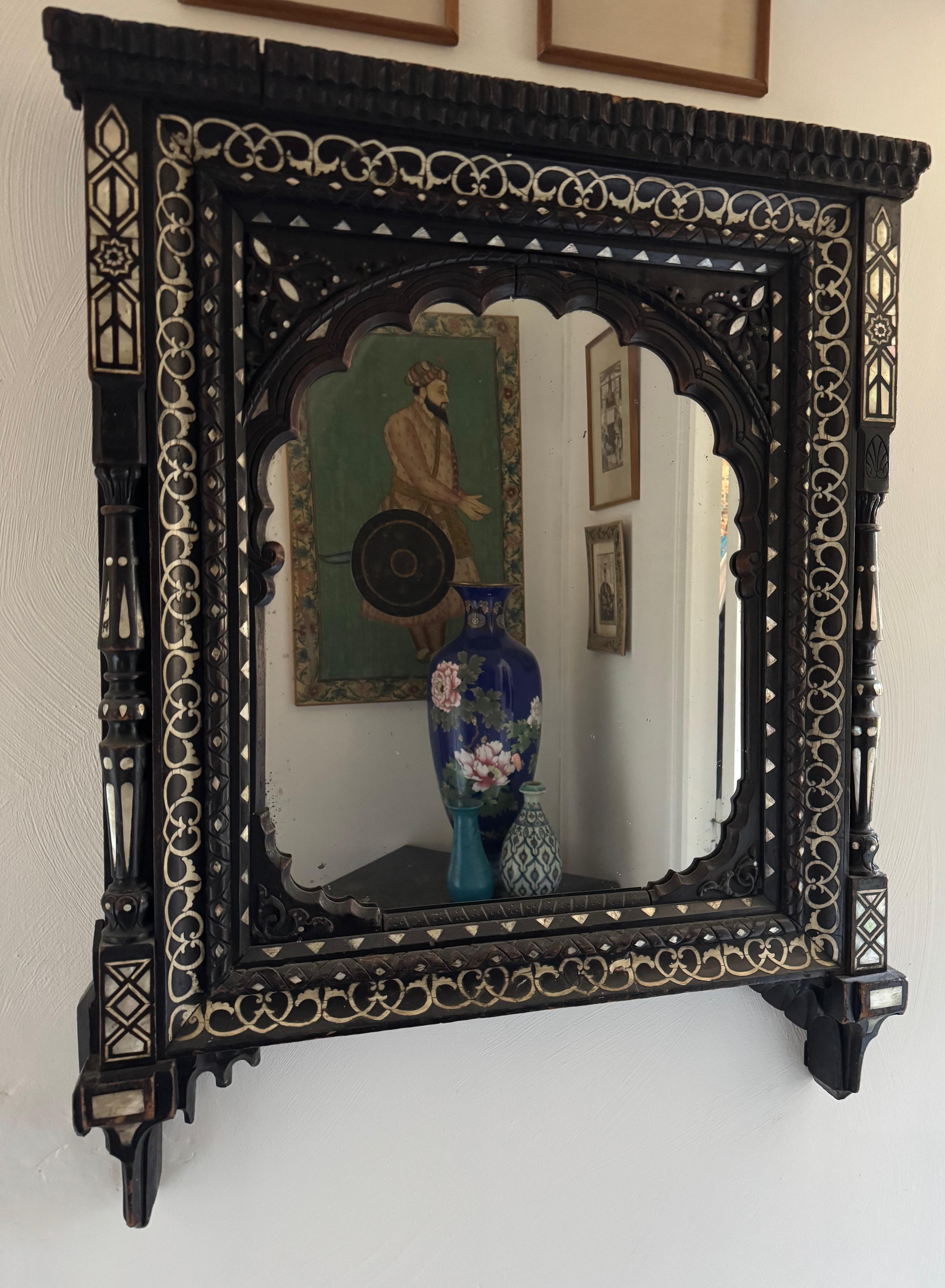Specchio con colonne in legno esotico, decorato con fogliame e motivi a intreccio, intarsiato con osso e madreperla.
Probabilmente del XIX secolo  Lavoro anglo-indiano.
Buone condizioni generali.
Dimensioni circa 90x70 cm 

