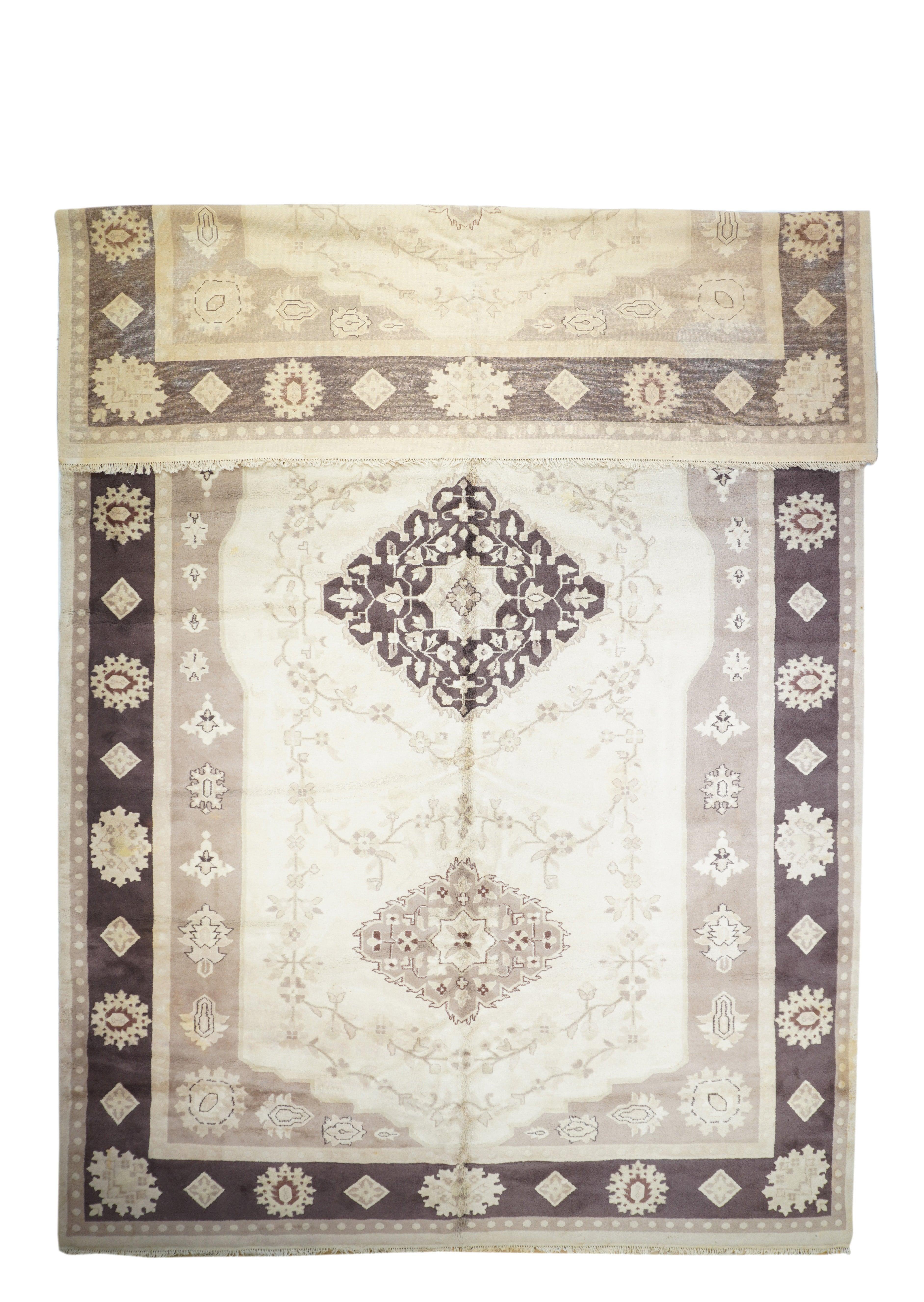 Tappeto indiano 10'11'' x 17'10''.  Il campo abrasivo, decorato con una varietà di semplici palmette, presenta un sottocampo alto a forma di cartiglio di colore ecru con tre medaglioni lozengoidali spinati e ben distanziati, incastonati in radi