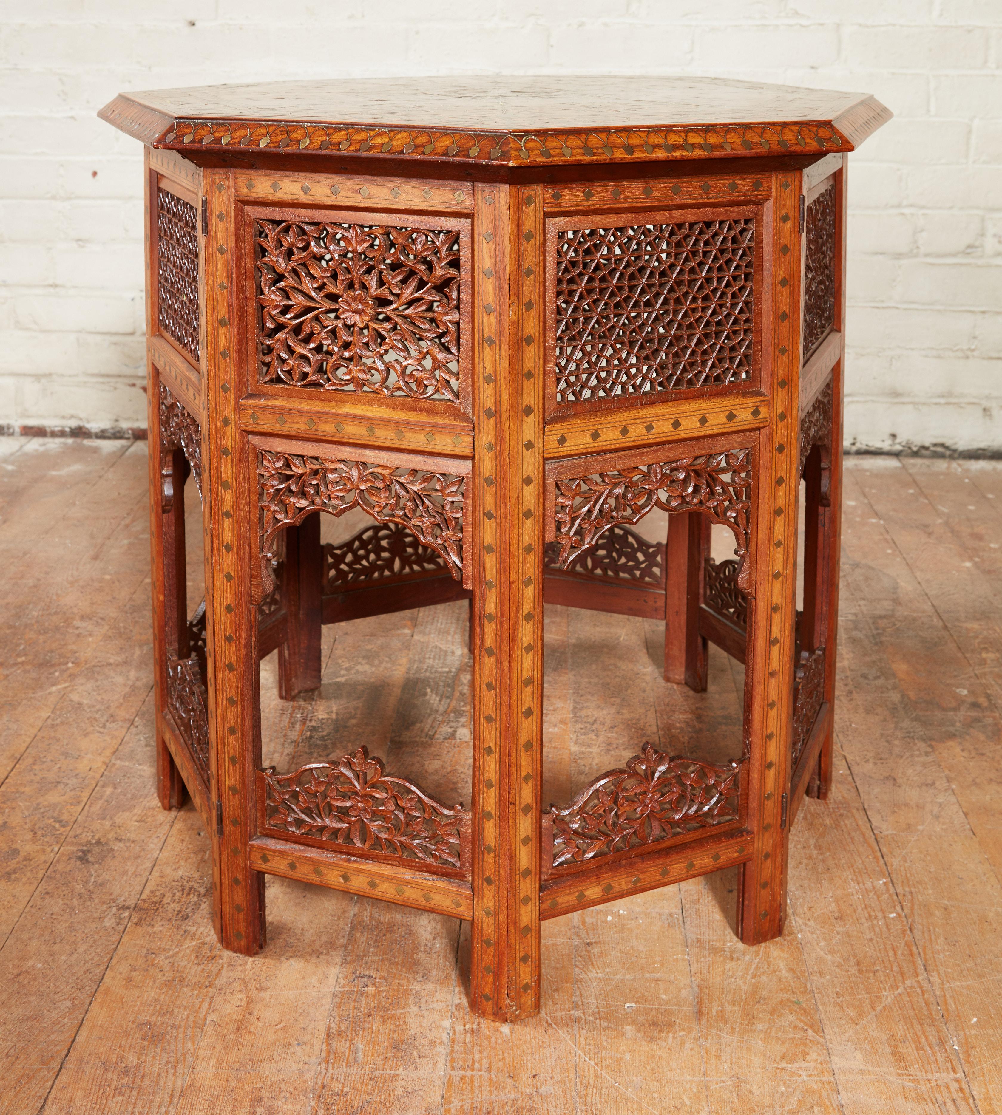 Fine late 19th Century Indian taboret table having mixed brass and copper and ebony inlay, the octagonal top with dazzling mixed metal details, the accordion action base similarly decorated and also with pierced carved panels and brackets, the whole