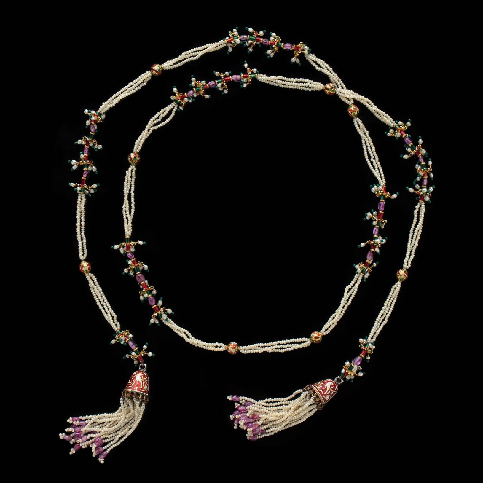 A stylish and colorful 14k gold necklace Mughal style lariat, circa 1950's,  designed with seed pearls and accented with red, green and white enamel, and sapphire beads. Overall length is 42