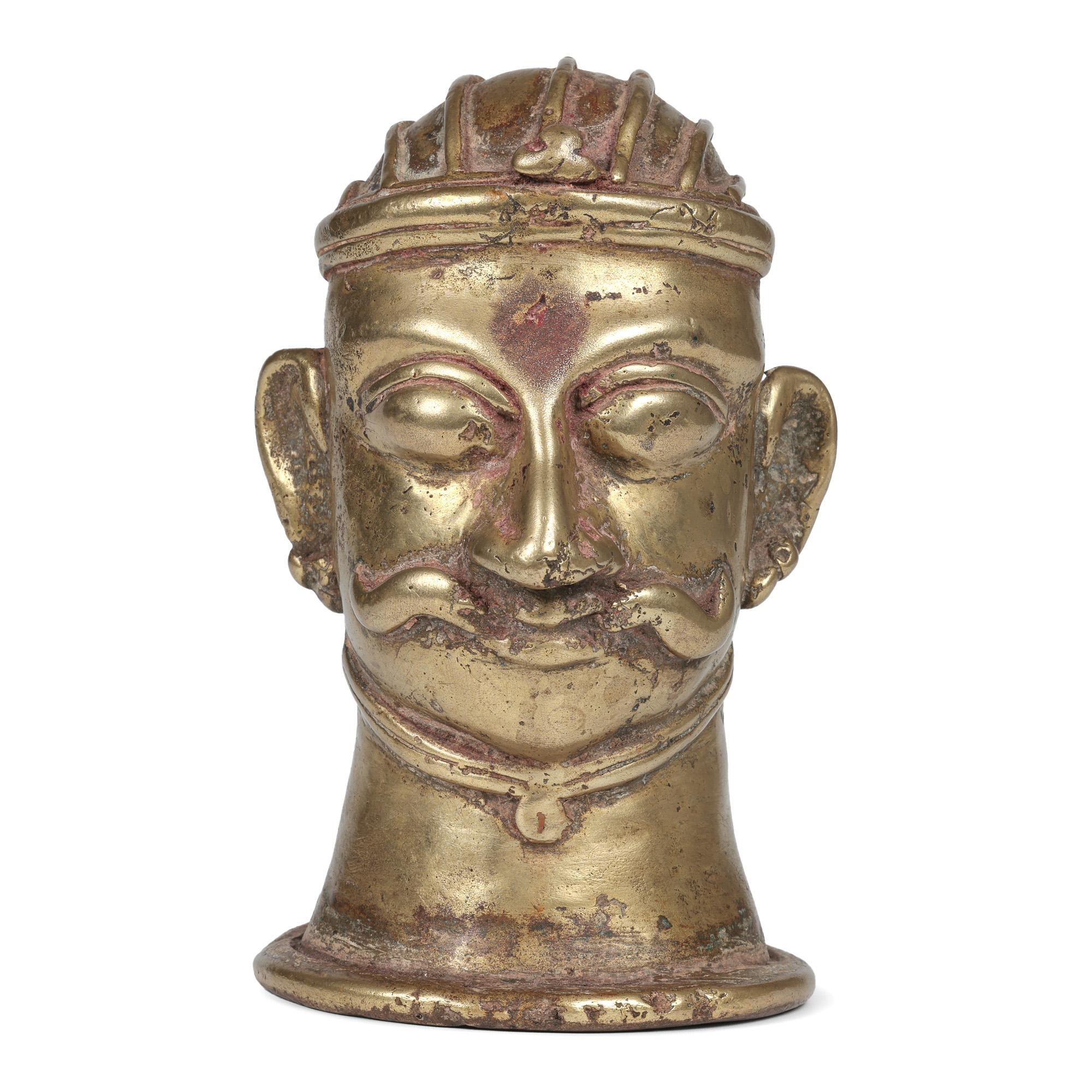 An antique Indian Shiva Mukhalingam made from a brass alloy and formed as a human face dating from the 18th century.

The Shiva Mukhalingam has a single face (some come with four or five faces) and is hollow formed as a sheath and is placed over a