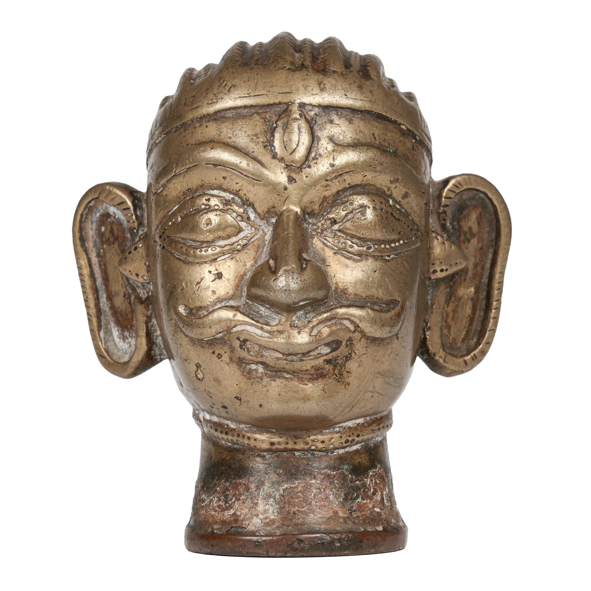An antique Indian Shiva Mukhalingam made from a brass alloy and formed as a human face dating from the 18th century.

The Shiva Mukhalingam has a single face (some come with four or five faces) and is hollow formed as a sheath and is placed over a