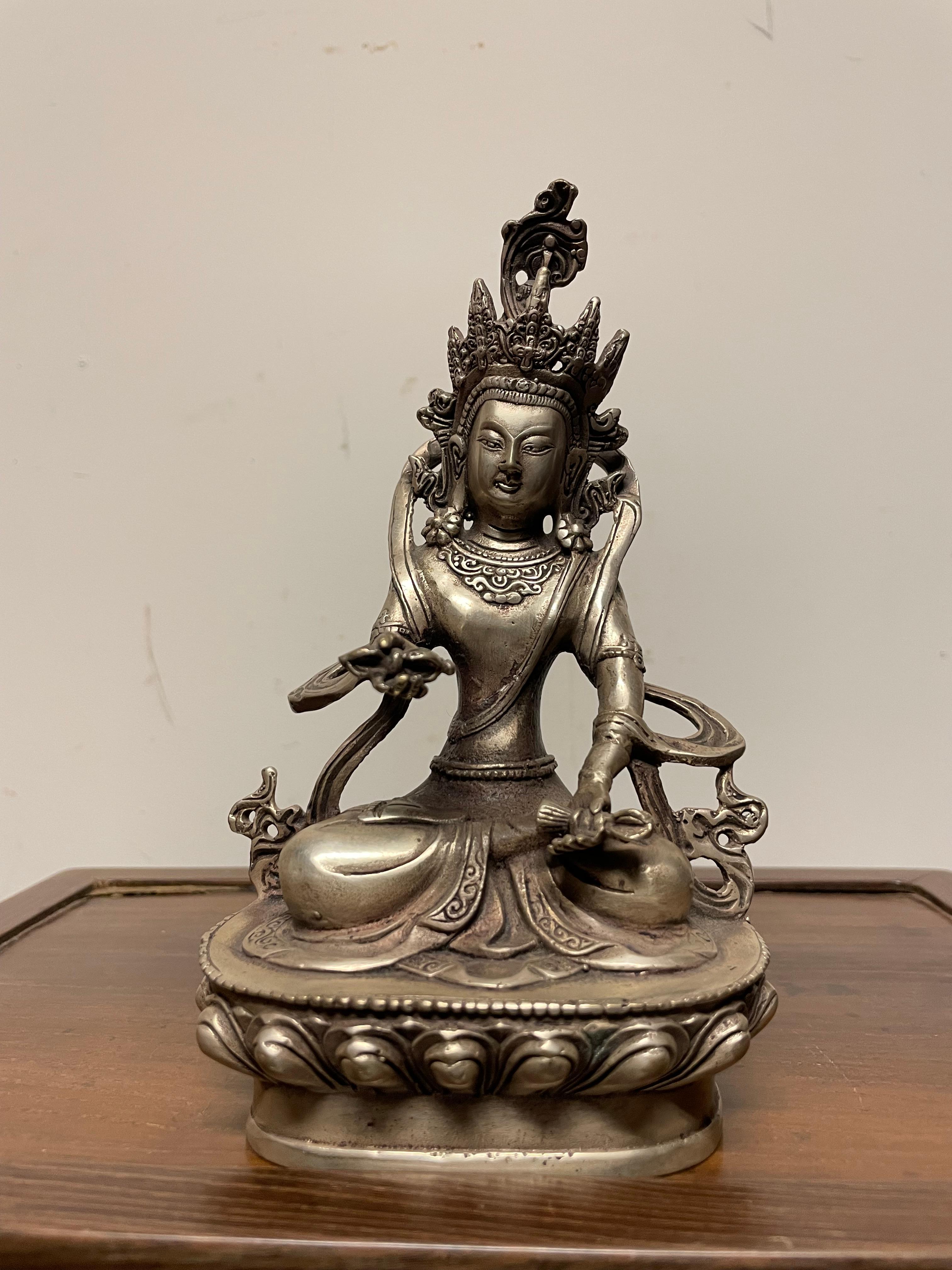 Wonderful small silvered bronze of Vajradhara. Indian, circa 1900. 
7 inches high by 4 wide by 3 deep

The Tibetan Buddhist deity Vajradhara is seated in a yogic meditation on a lotus pedestal. His hands hold identifying attributes, the dorje