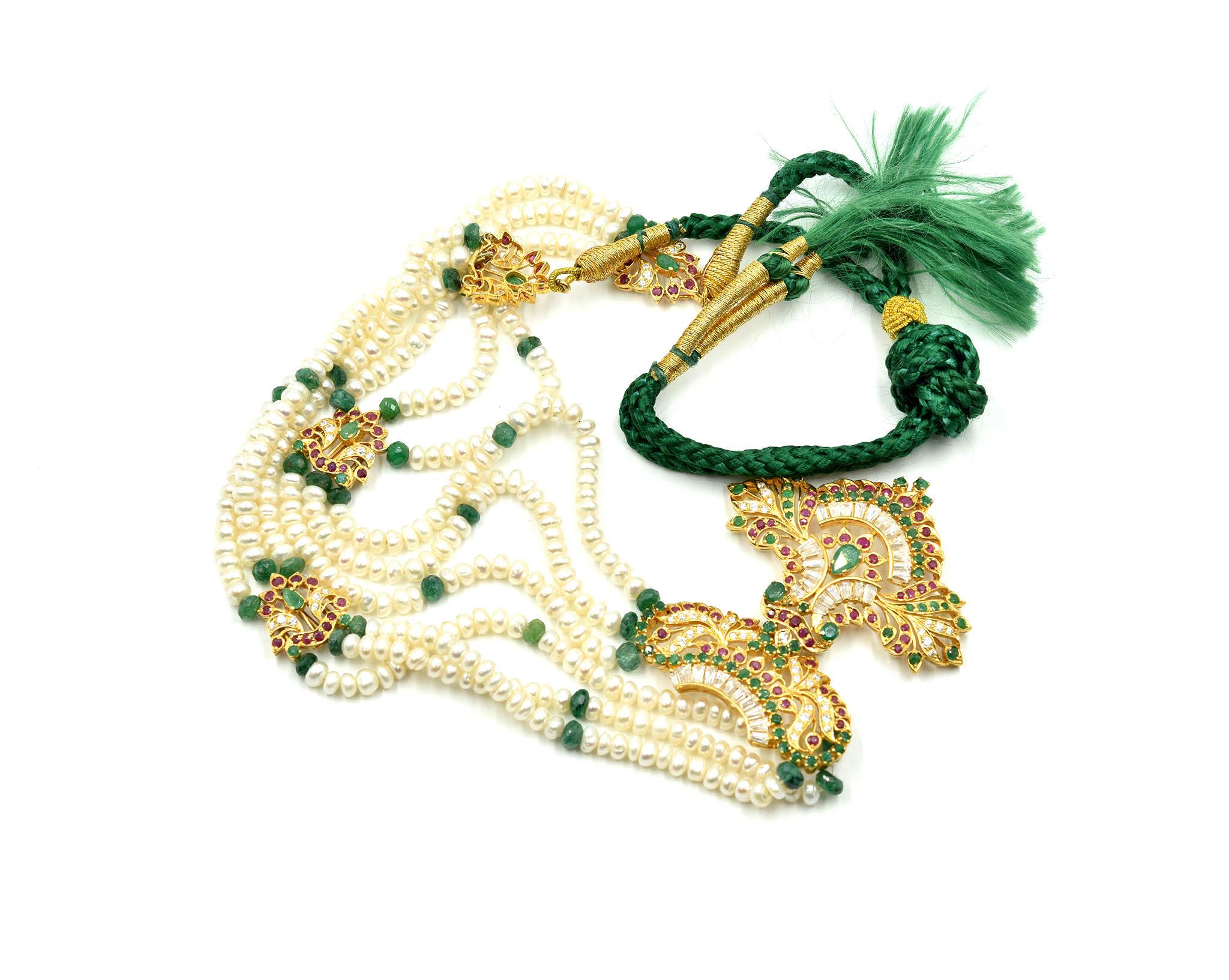 This necklace consists of ruby, emerald, CZ strung with pearls. Accentuating the pearl strung necklace are accents made with 22k yellow gold set with rubies and emeralds. Faceted bead emeralds are stationed along the necklace. The front of the