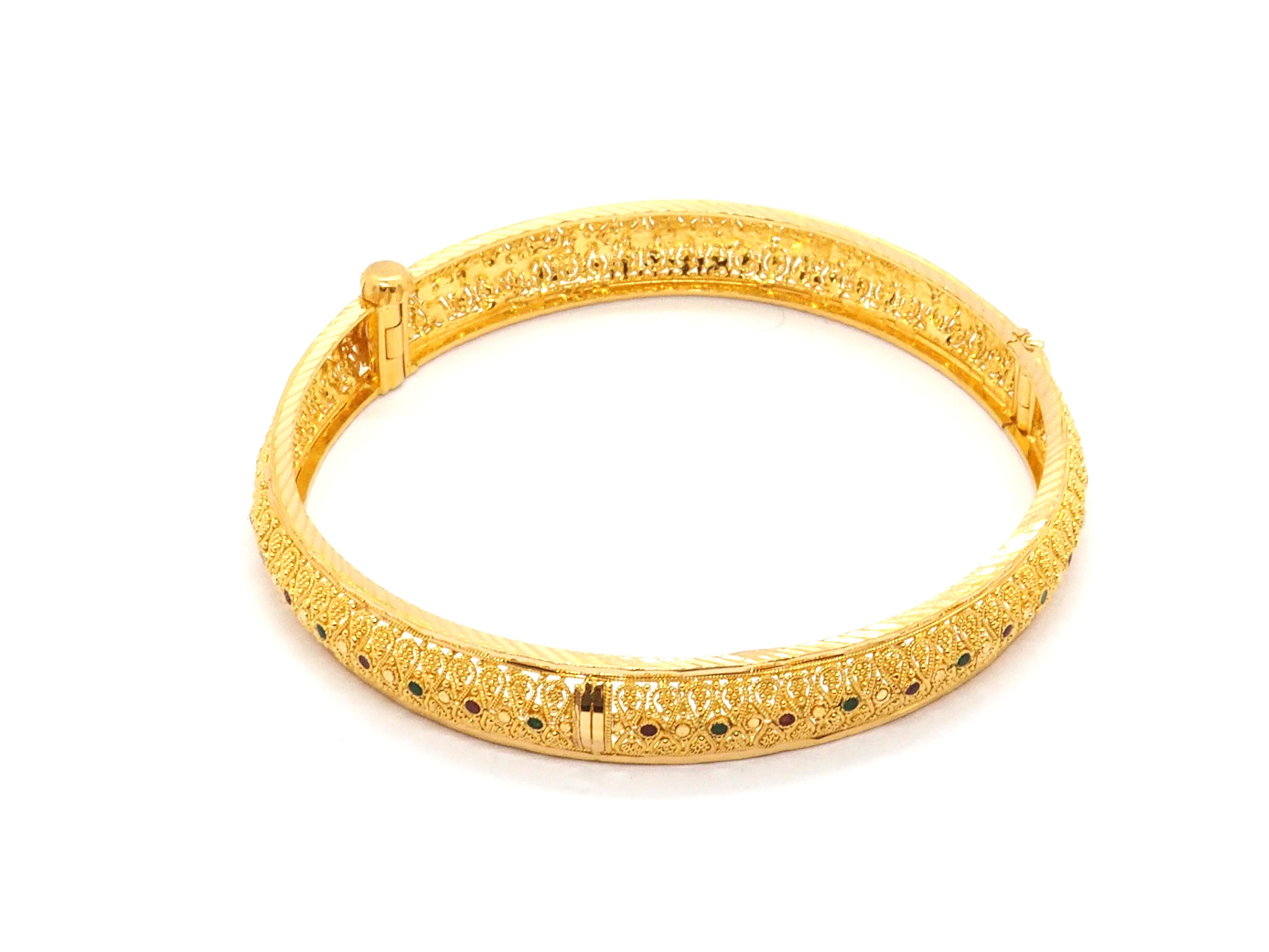 Embrace opulence with our stunning Indian-style bangle bracelet, crafted from 21k gold and adorned with enchanting enamel imitation rubies and emeralds. Weighing 25 grams, this exquisite piece radiates luxury and elegance, offering a timeless