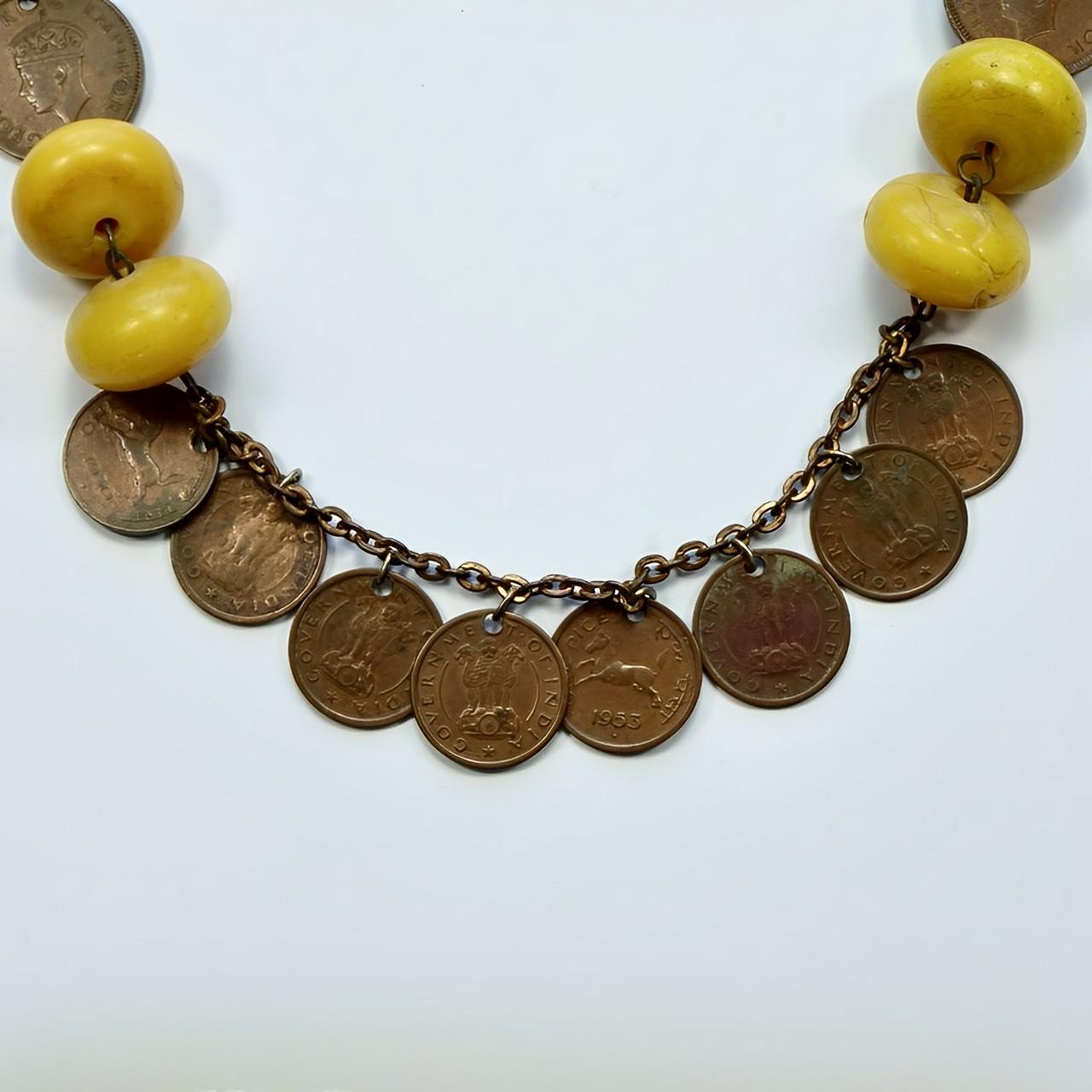 Merveilleux collier de pièces de monnaie tibétain indien avec des perles en résine jaune. Les pièces sont datées de 1908 à 1954. La chaîne est plaquée de cuivre, la plupart des plaquages sont usés. Le fermoir a été remplacé. Longueur 75,7 cm / 29,8