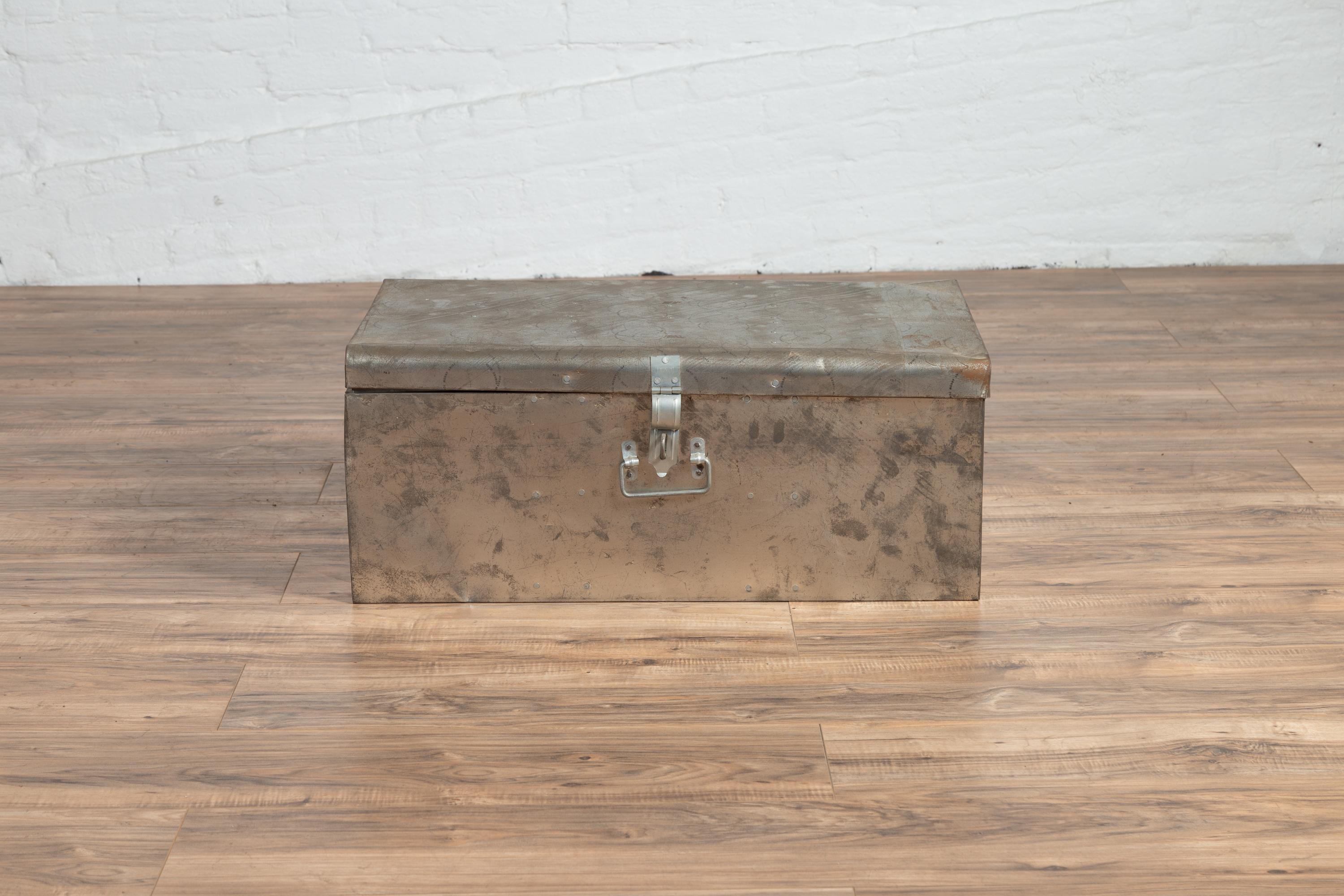 A vintage Indian metal tool box with silver colored finish from the late 20th century. Born in Indian during the third quarter of the 20th century, this industrial looking tool box features a rectangular lid with circular stamped patterns, that