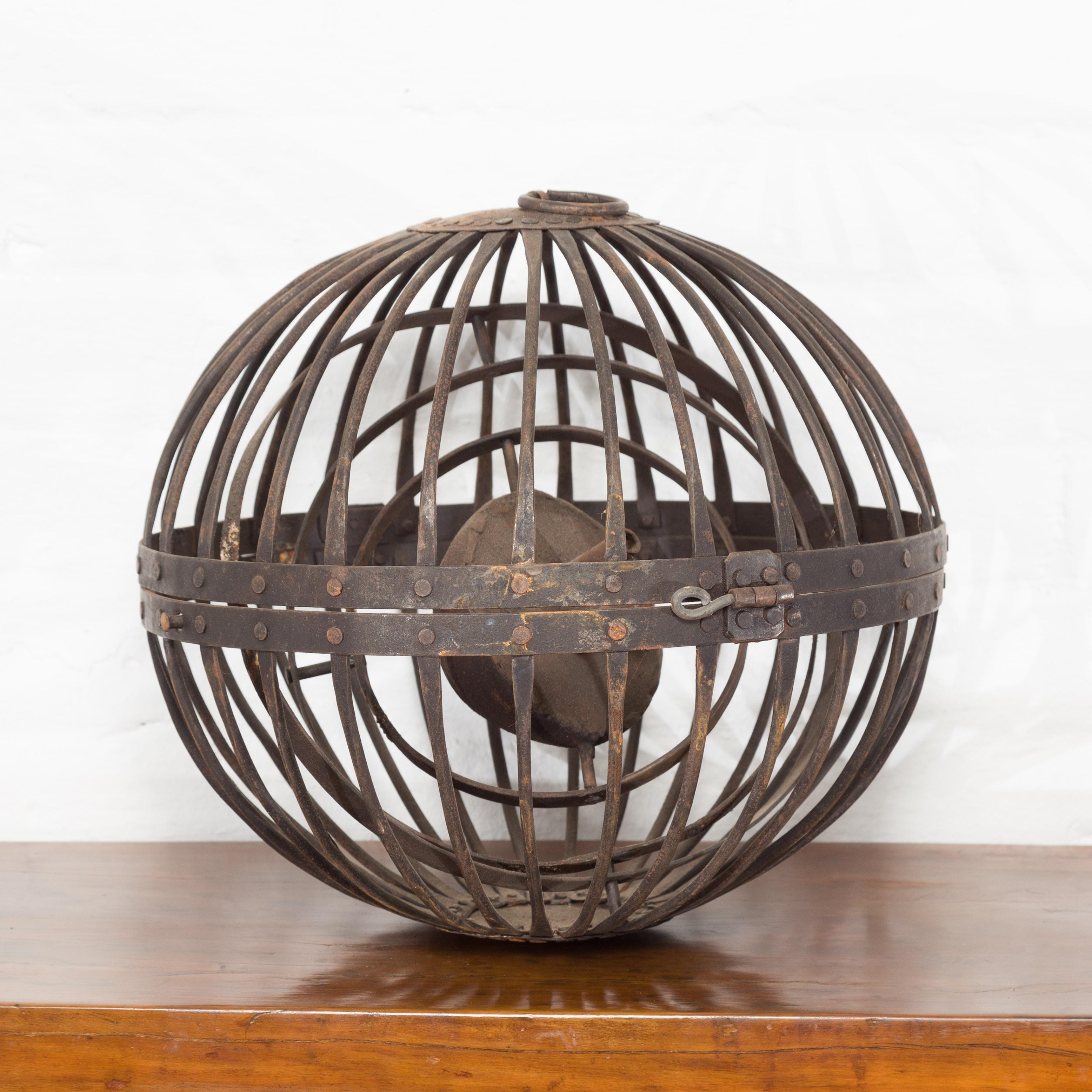 An Indian vintage spherical iron light fixture from the mid 20th century, unwired. We have several available, priced and sold individually. Created in India during the midcentury period, this iron light fixture, unwired, captures our attention with