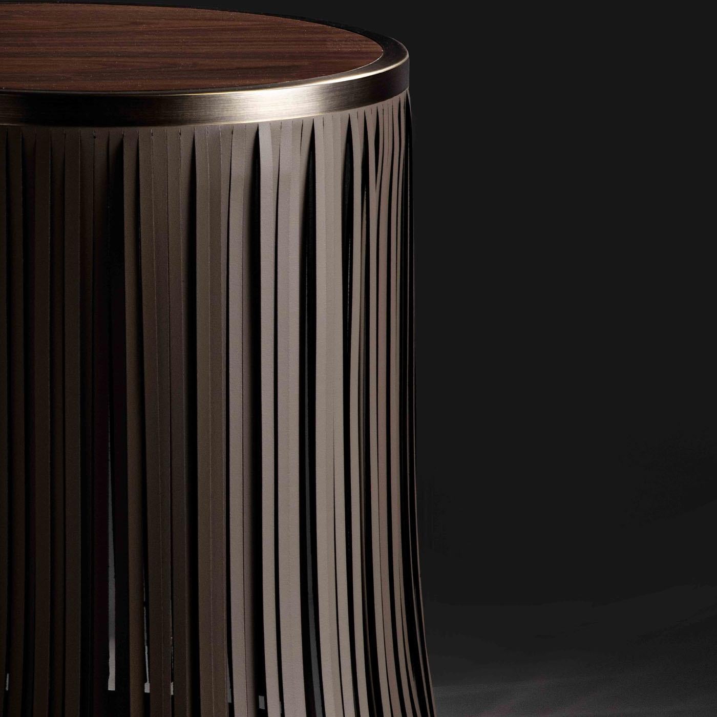 Ringed in brushed brass, the round Canaletto walnut wood top and base of this exquisite side table are graced by a glamorous silver-gray leather fringe that will make a spectacular statement in both minimalist and rustic interiors. A display of