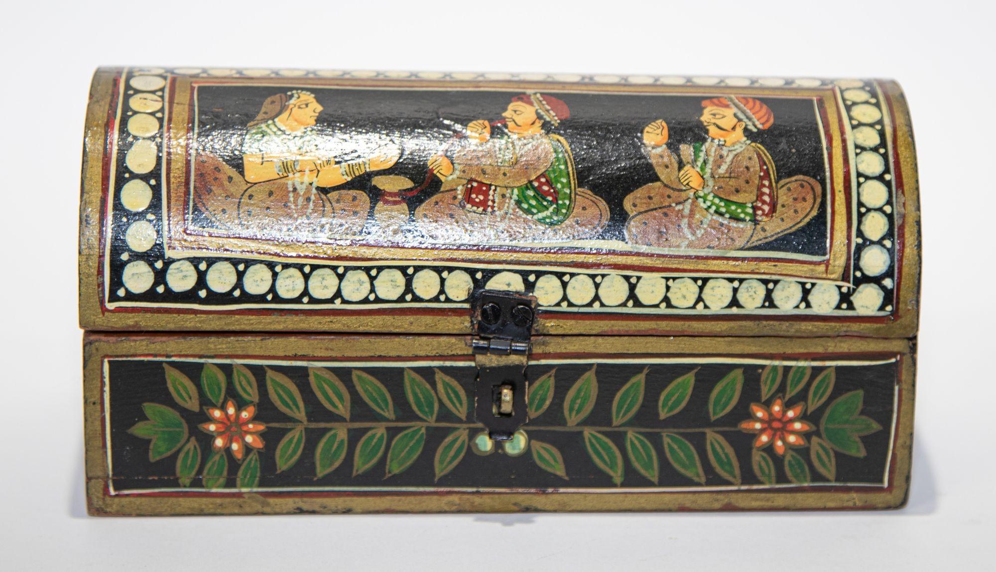 Le plumier indien rectangulaire avec couvercle à charnière bombé est peint à la main avec des scènes de cour figuratives colorées du Maharajah sur le dessus et des motifs floraux sur chaque côté.
Plumier décoratif Rajasthani peint à la main.
En