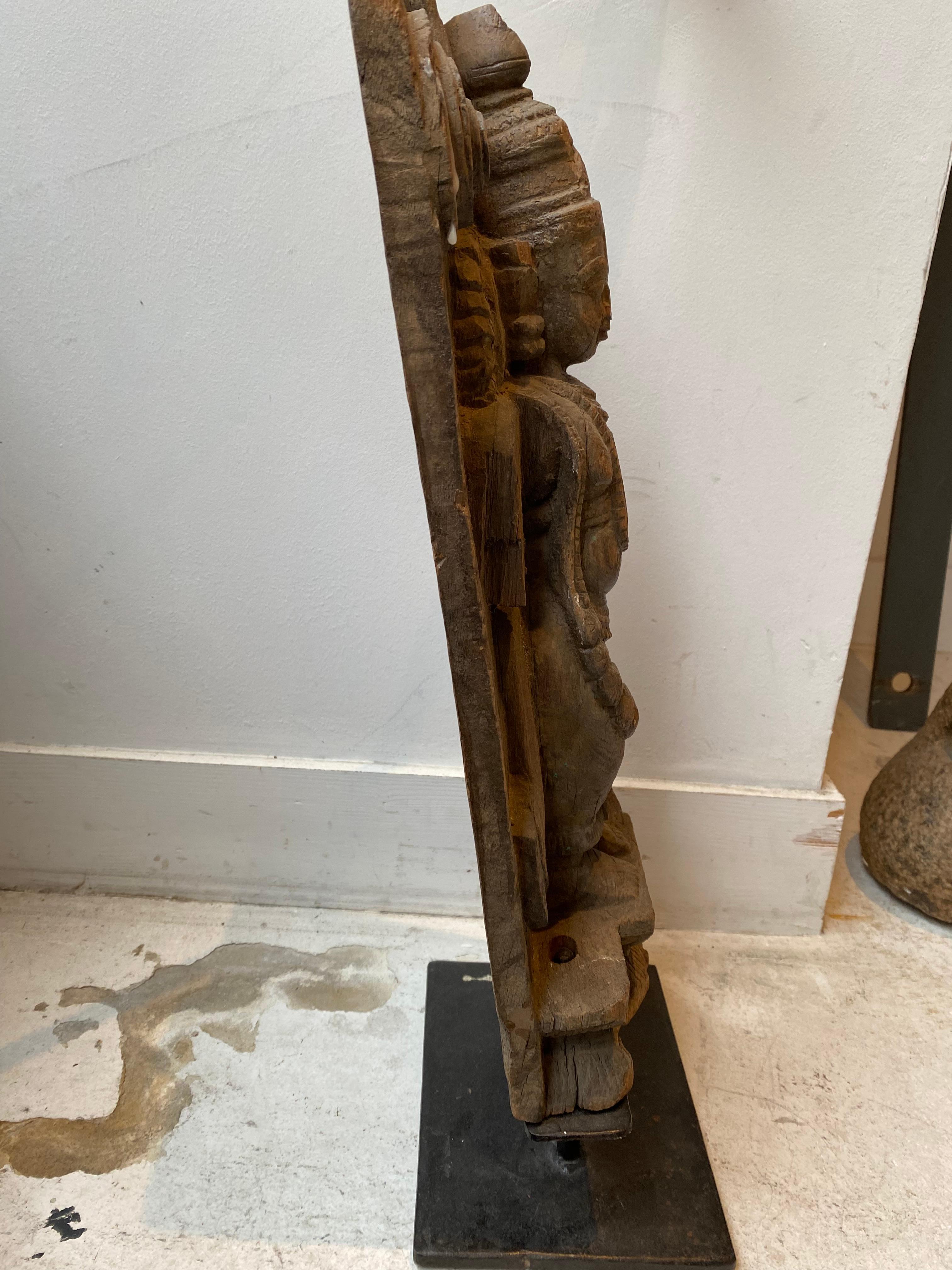 geschnitzte Holzskulptur, die eine Frau darstellt
er ist auf einem modernen Metallsockel montiert
Es stammt aus Rajasthan 