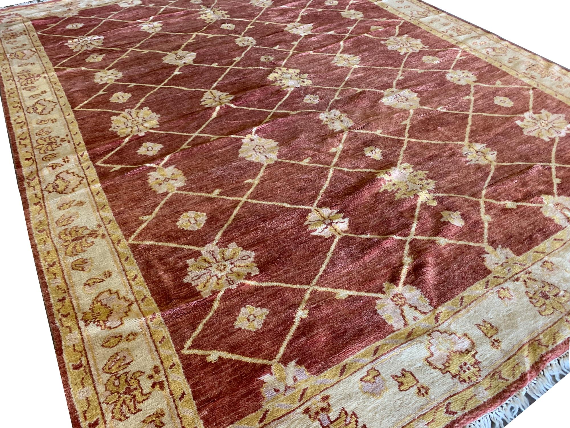 Dieser indische Ziegler-Teppich ist ein Meisterwerk von zeitloser Eleganz und handwerklicher Kunstfertigkeit. Dieser mit akribischer Präzision handgeknüpfte Vintage-Teppich besticht durch eine Mischung aus satten Rot- und dezenten Beigetönen, die