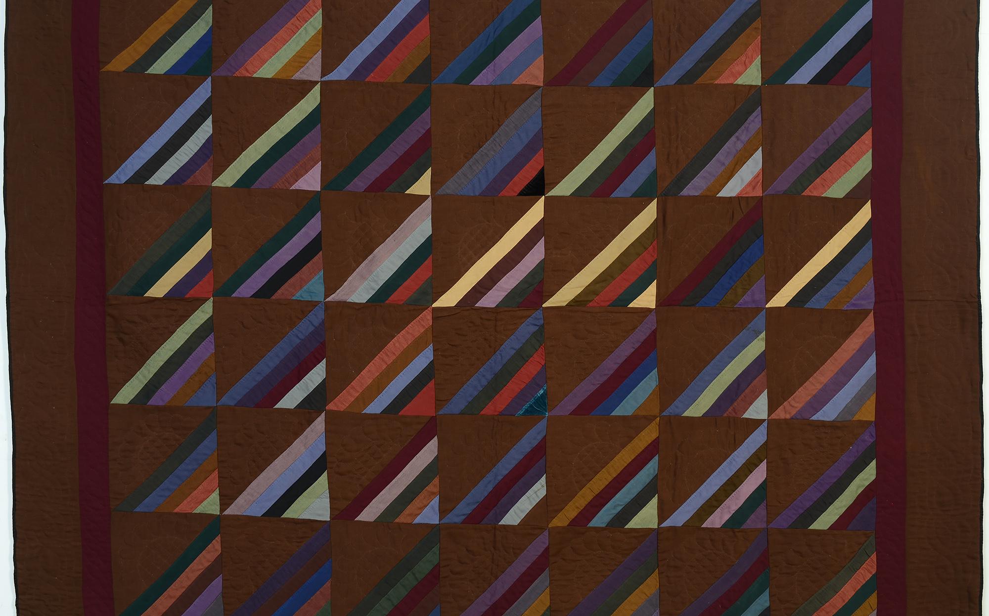 Stunning version of a Roman Stripe quilt done on an unusual dark brown ground. The quilt is almost all wool with occasional pieces of velvet and cotton sateen. The fabric of the maroon inner border is used throughout the quilt. Both borders are