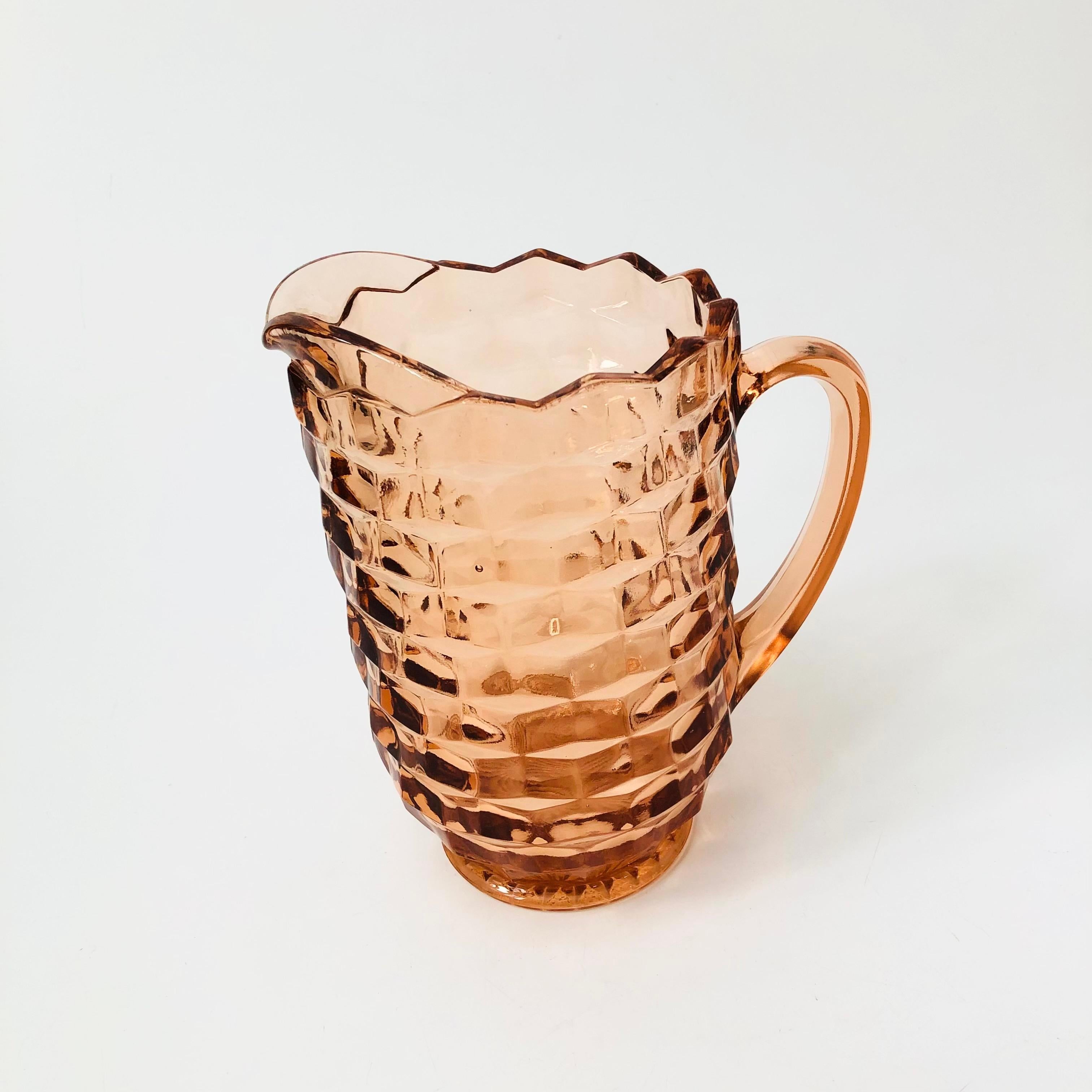 A vintage pitcher in a cubist design in blush pink glass. Made in the Whitehall pattern by Indiana Glass. Smooth interior. Perfect for serving drinks.

