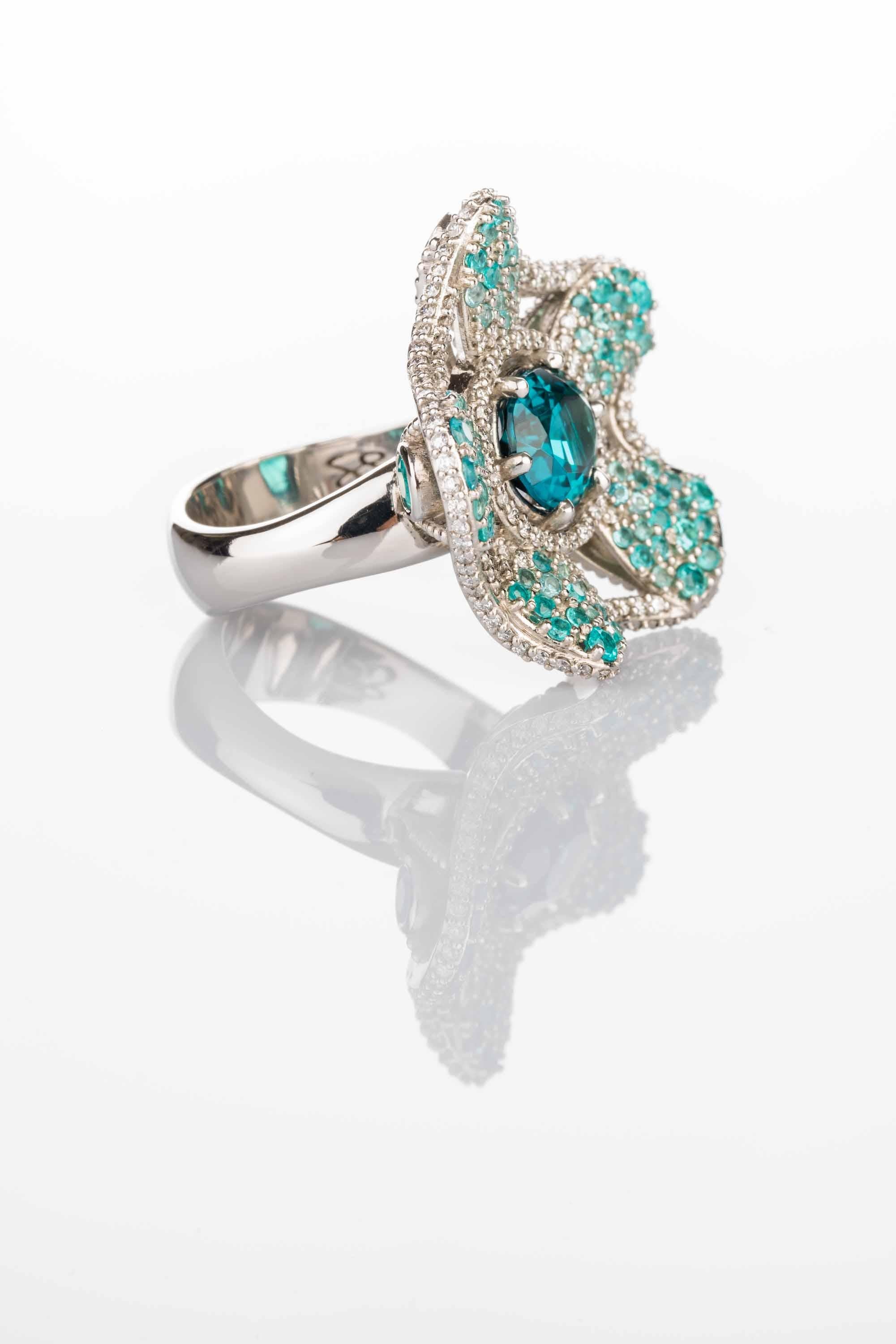A platinum ring set with a faceted oval indicolite tourmaline 2.49 carats, 0.78 total carat weight round full cut white diamonds F color VS clarity, 0.86 total carat weight round full cut intense blue Brazilian Paraiba tourmaline, 0.71 total carat