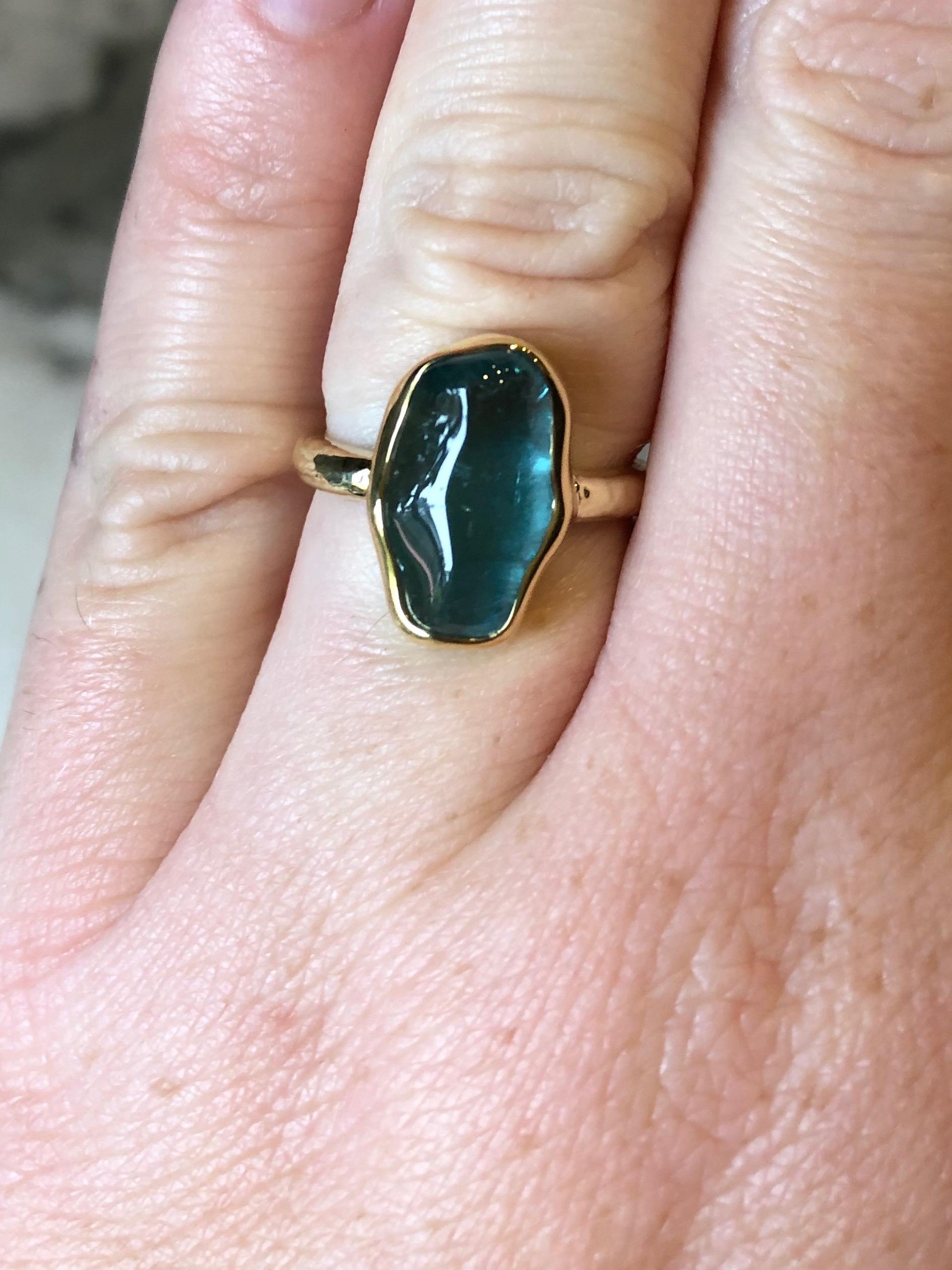 Performs miraculously in every light; a glacial blue. German cut baroque indicolite tourmaline in our hand fabricated 100% recycled gold 18 karat setting. Part of our baroque gem collection. Polished bezel, hand hammered shank.

Indicolite