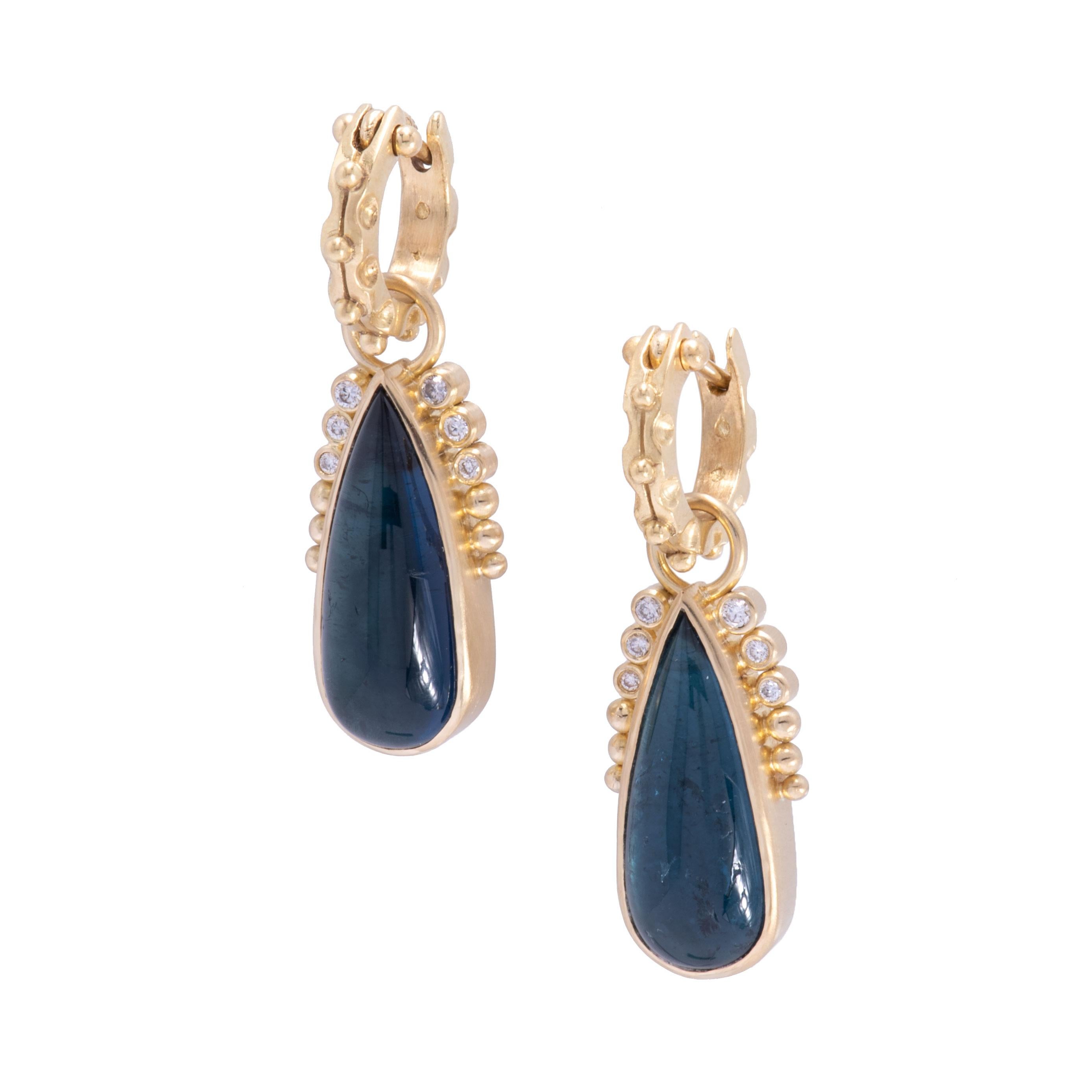 Blue-green indicolite tourmaline long teardrop cabochons are bezel set in 18k gold and crowned with beading and .18tcw white diamonds. 12.13tcw indicolite tourmalines are deeply colored and lush with interior landscape. They hang from our gardenia