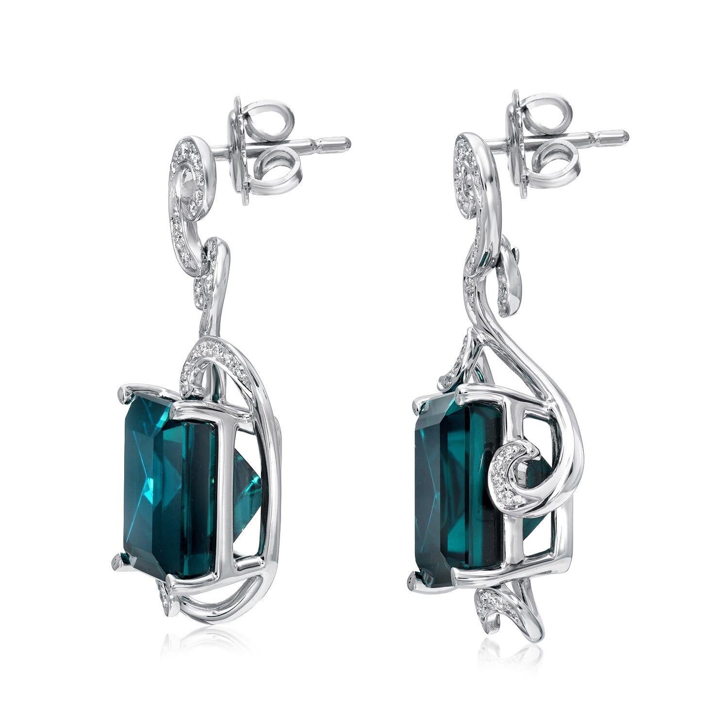 Indicolite Tourmaline earrings, set with a unique emerald cut pair of sea foam greenish blue Indicolite Tourmalines weighing a total of 12.98 carats, and adorned by a total of 0.24 carats of round brilliant diamonds, in 18K white gold.
Drop earrings