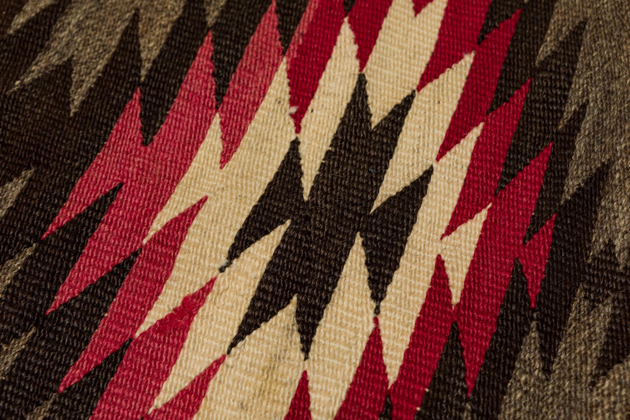 Tapis indigène américain (peut-être Navajo) rectangulaire tissé avec un motif géométrique en losange rose, beige et marron, sur un fond beige et marron tacheté avec une bordure géométrique marron et beige audacieuse.

Condit : Bon ; Usures dues à