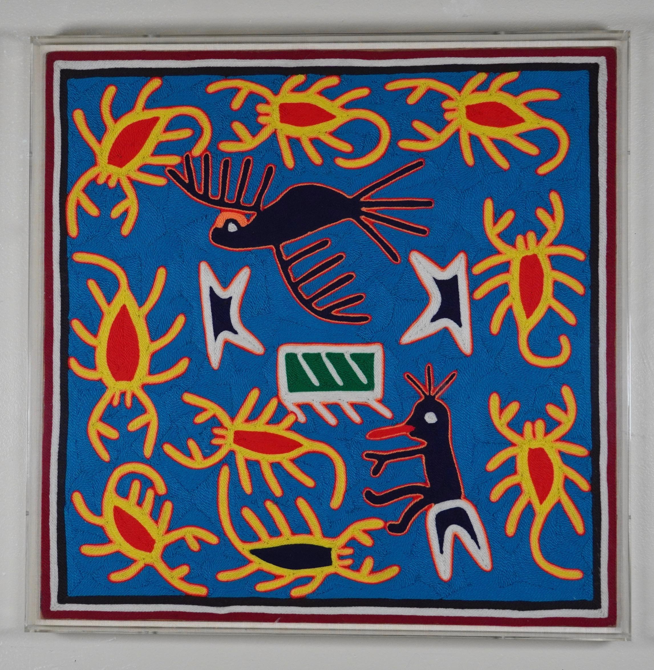 Textile wall art from the Indigenous peoples of Latin American, applied twisted fiber on board mounted on a custom linen backed acrylic shadow box frame. The colors of the work are blue red, yellow, black and white. The image tells the origin story