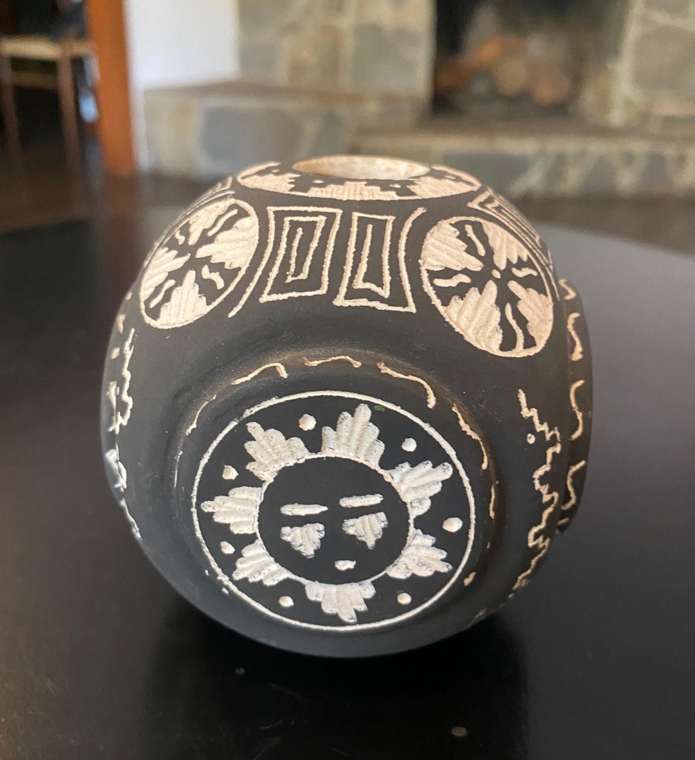 A wonderfully crafted, hand painted Native American Navajo pottery black and white vase featuring images of the sun and various geometrical designs.  

Signed (