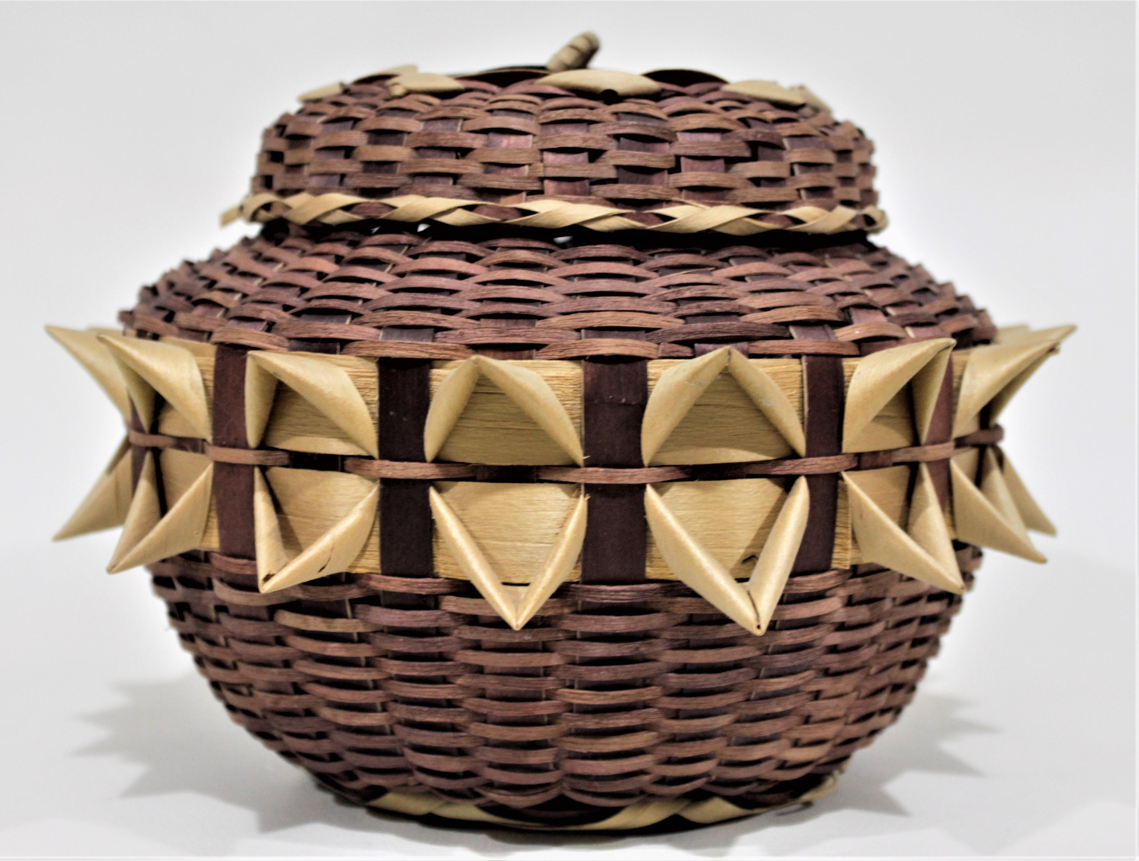 This Indigenous styled lidded basket is presumed to have been made in the United States in circa mid-late 20th century. The maker of the this basket is unknown, but done in the style of the North American indigenous people using the 'porcupine