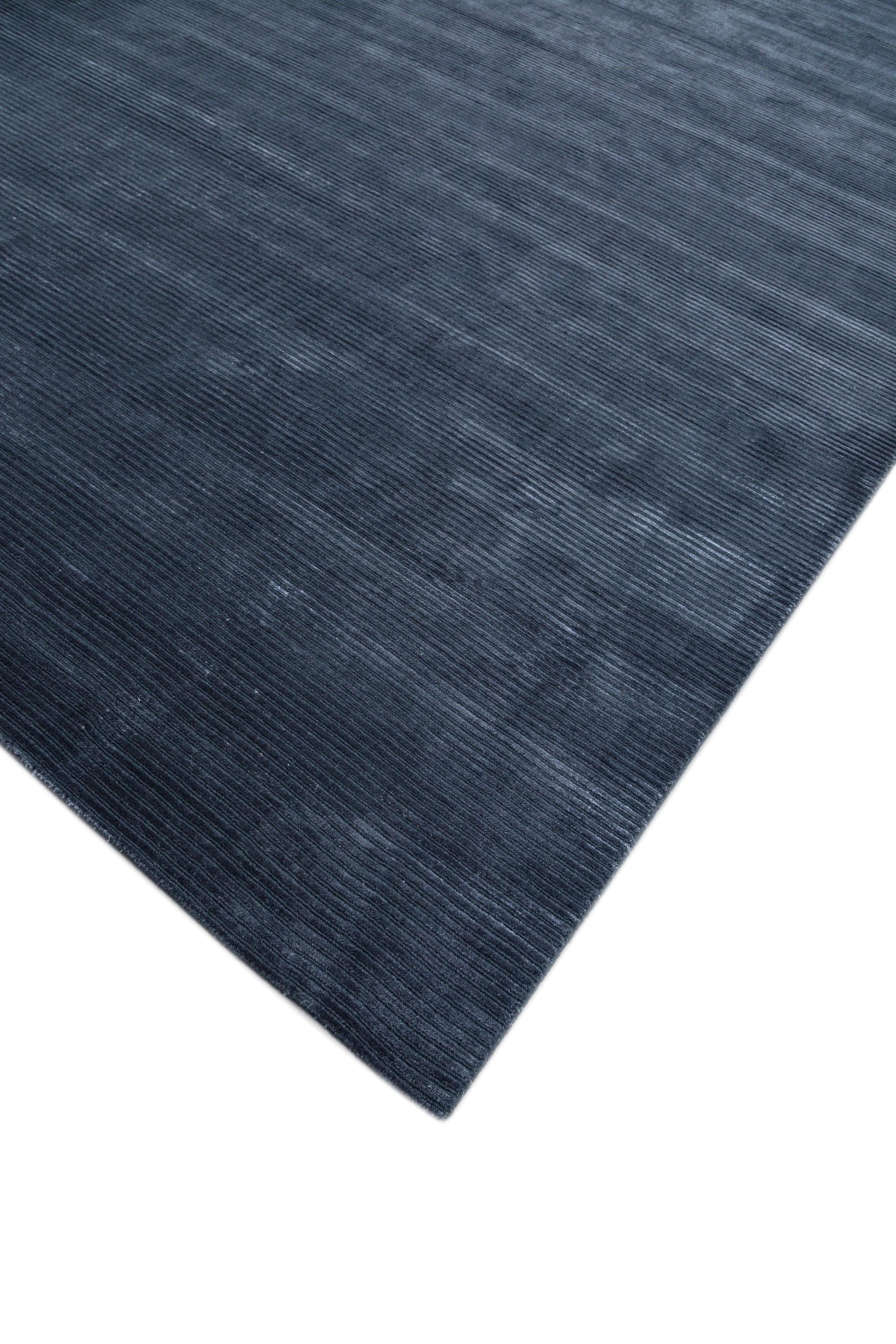 Like strokes of midnight ink on an artist's canvas, Jaipur Rugs unveils a hand-loomed masterpiece with a bold indigo blue tone-on-tone color scheme. This lightly-distressed, modern rug, crafted from a luxurious blend of wool and viscose, presents a