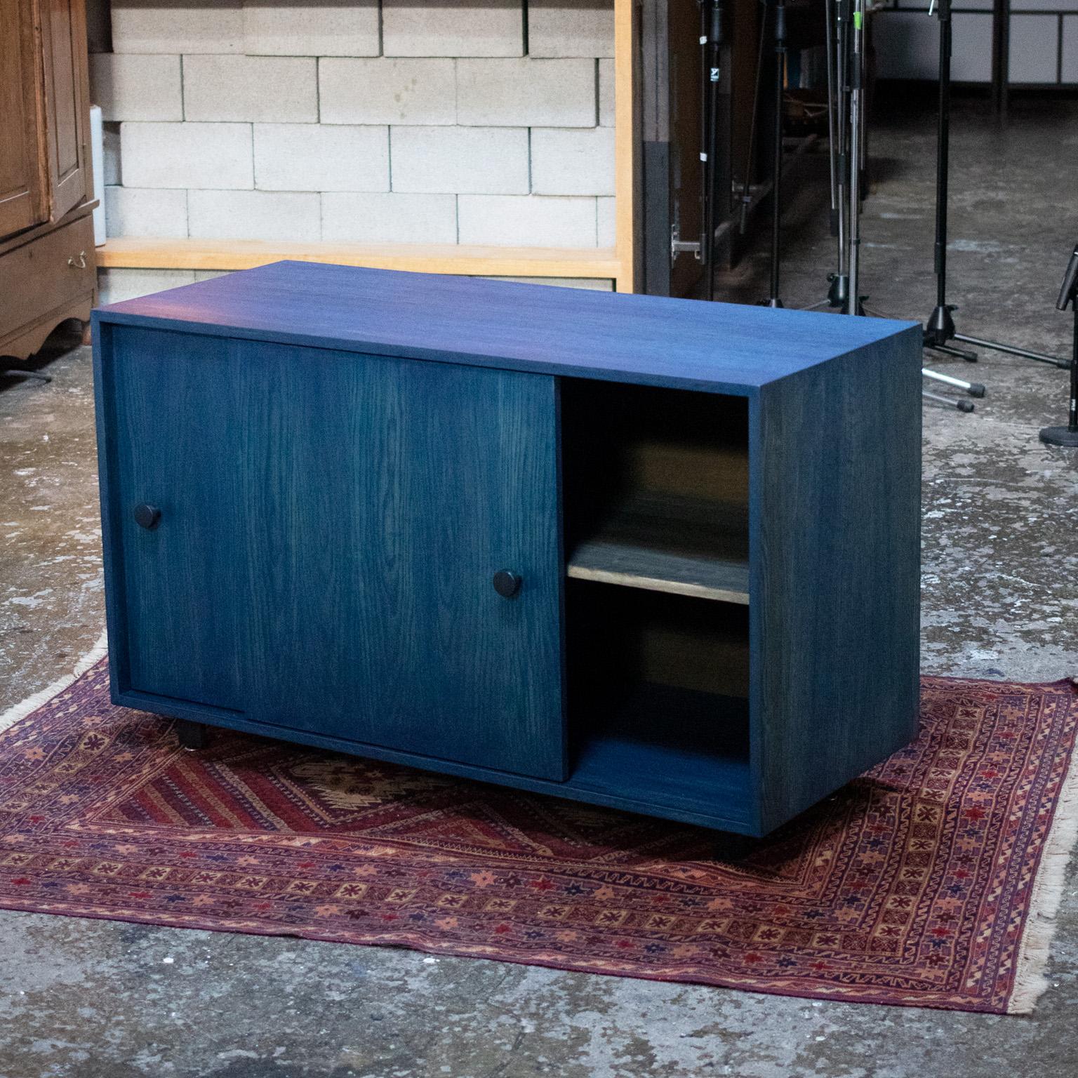 The Aquinas cabinet is a compact, sliding door cabinet perfect for records, books, and smaller items. Intended for light storage this cabinet is minimalist in design featuring Swedish hardware. Crafted from oak this cabinet is lightweight, sleek,