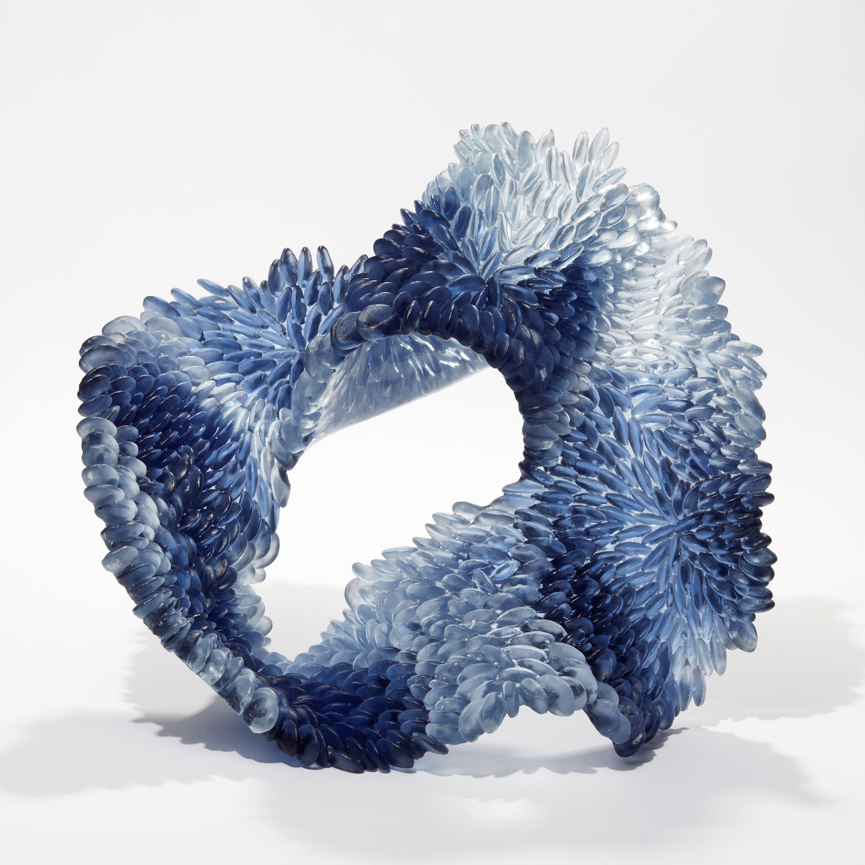 'Indigo Blues II' is a unique glass sculpture by the British artist, Nina Casson McGarva.

Casson McGarva firstly casts her glass in a flat mould where she introduces all of the beautifully detailed, scaled surface texture, all unique and to her