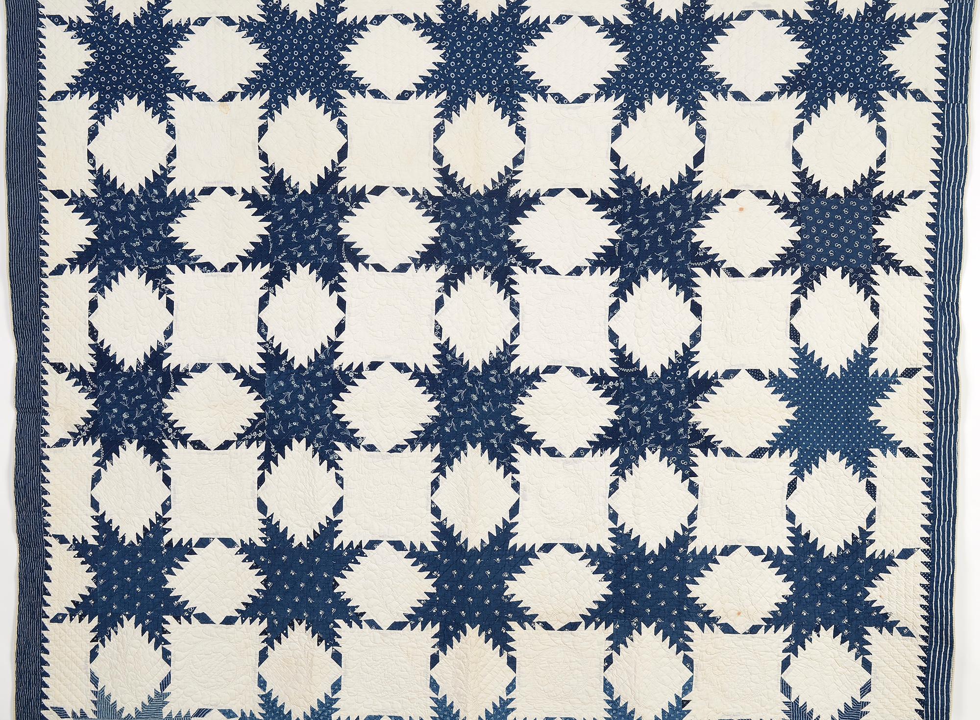 The pattern, quilting and fabrics all combine to make this Feathered Stars quilt an outstanding example. The twentyfive stars are surrounded by beautifully quilted wreaths and feathers in the white blocks. The stars are made of a variety of indigo
