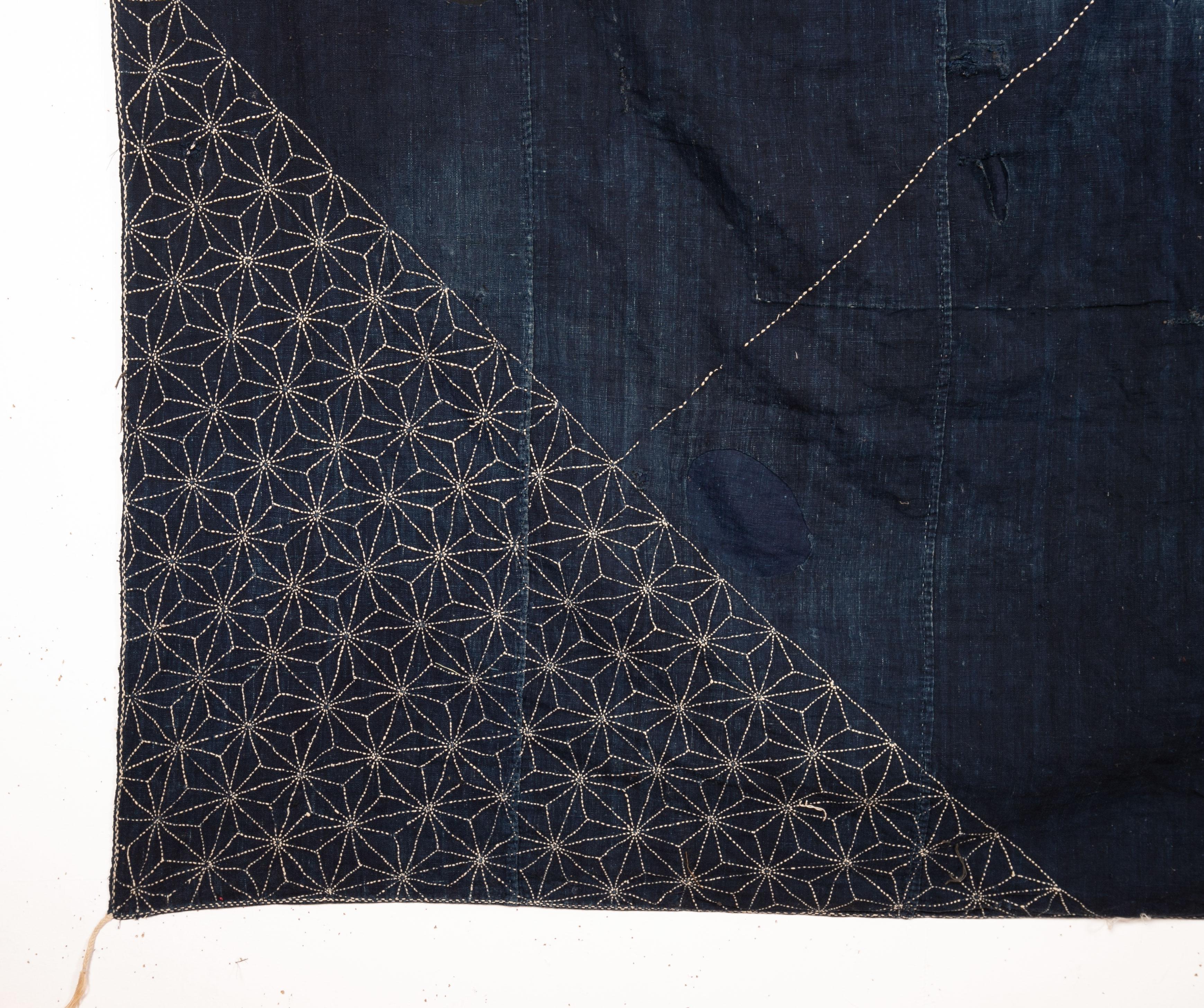 Indigo textile decorated with 'sashimi' stitching. Has some damage including a big patch.