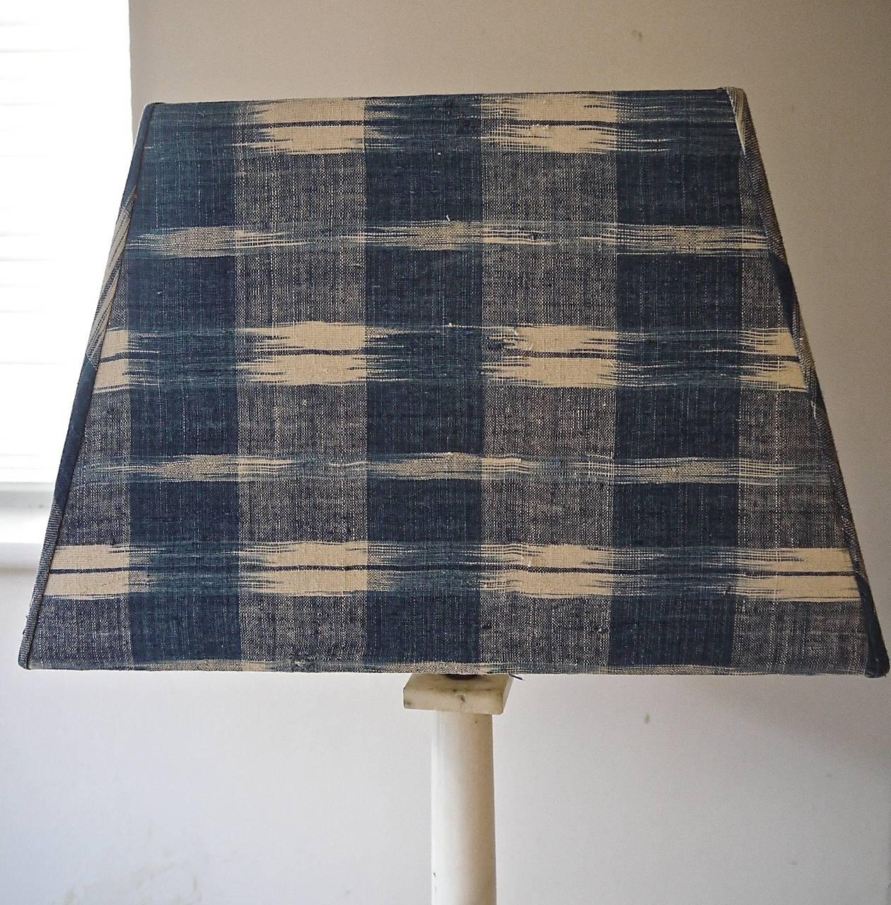 French late 18th century beautifully and softly faded indigo ikat/flamme coarsely woven cotton covering a tapered custom-made lampshade.
The inside is covered in an off white cotton.