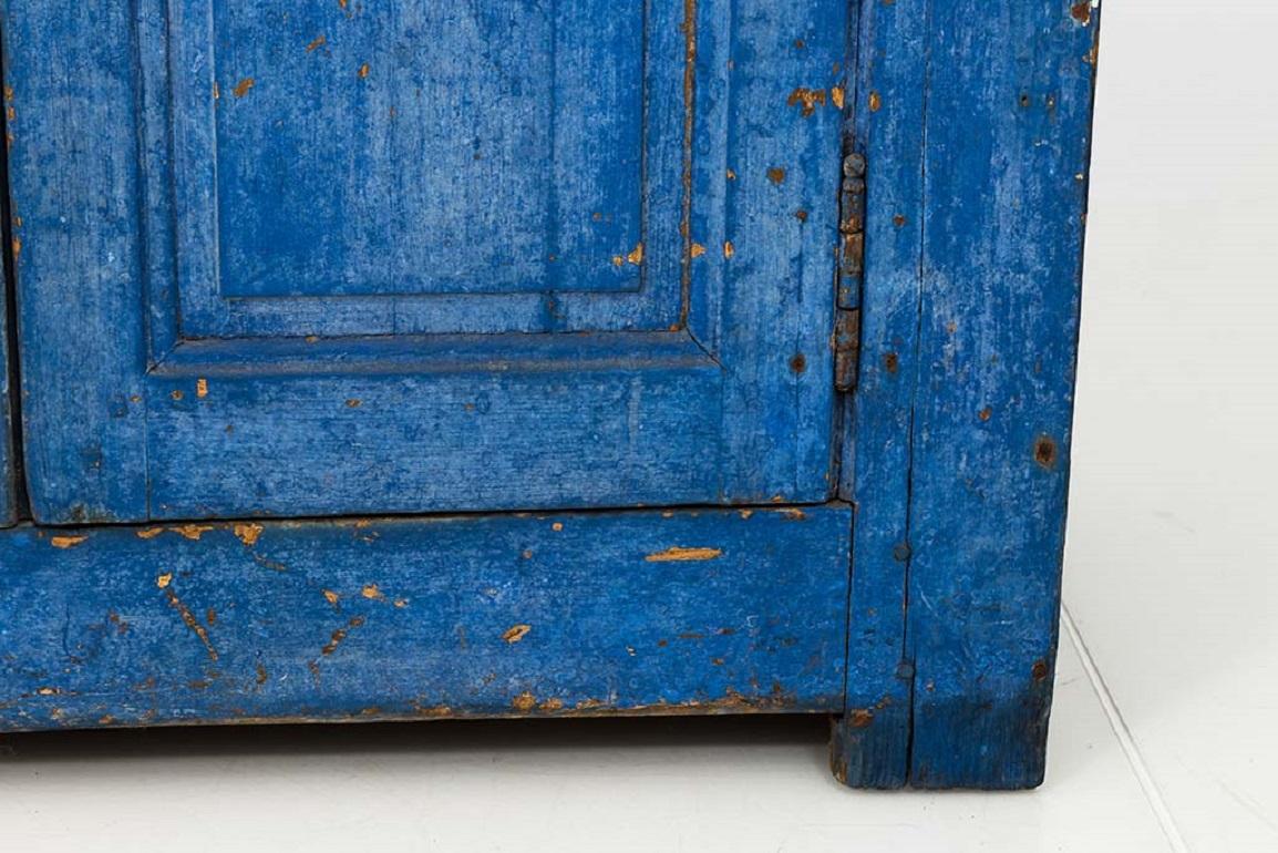 Gorgeous French Country style two-door wooden cabinet, made in the mid 19th century. Painted in a bold cerulean blue, this provincial cupboard is otherwise simple and restrained. The cabinet doors feature clean lines throughout the molding that