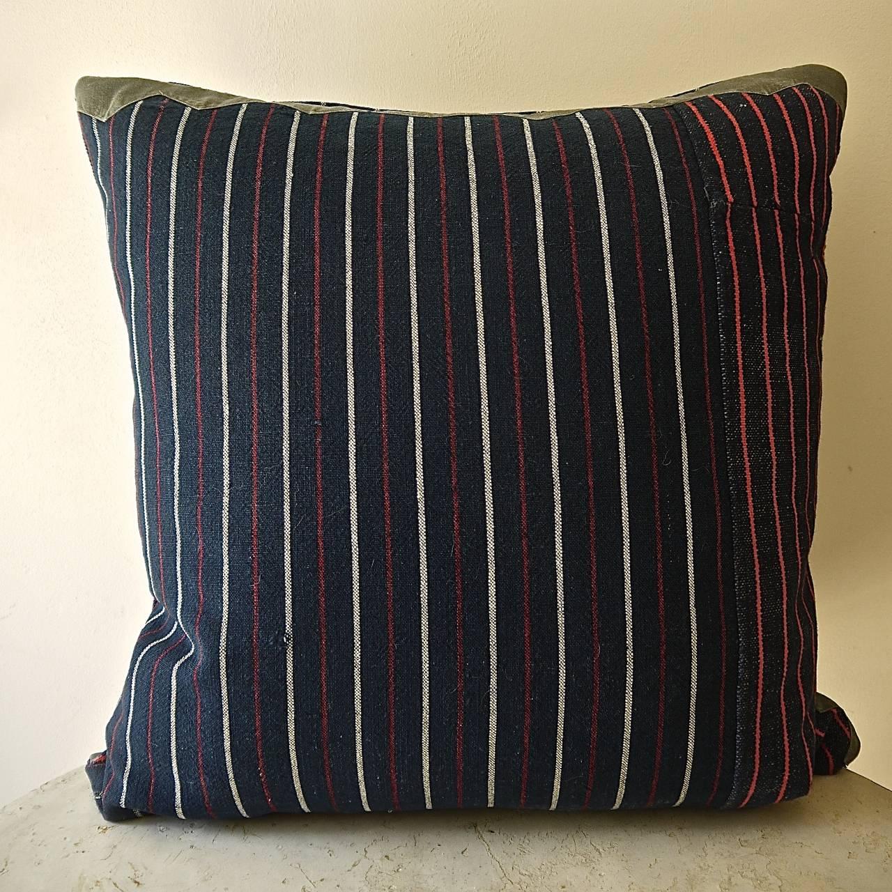 French 19th century woven cotton and wool striped cushion of dark indigo with white, red colors. Original piece made up of two different stripes with an 'as found ' border of a French 19th century grey cotton trim at the top of one side and on the