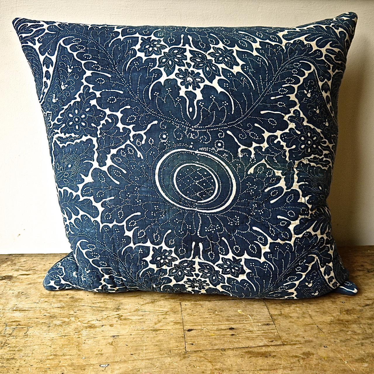 French indigo resist block printed cotton cushion probably from Rouen in Northern France. A striking design of arching acanthus leaves and stylized floral and leaf motifs. Simply quilted and backed in a natural indigo dyed 19th century French linen.