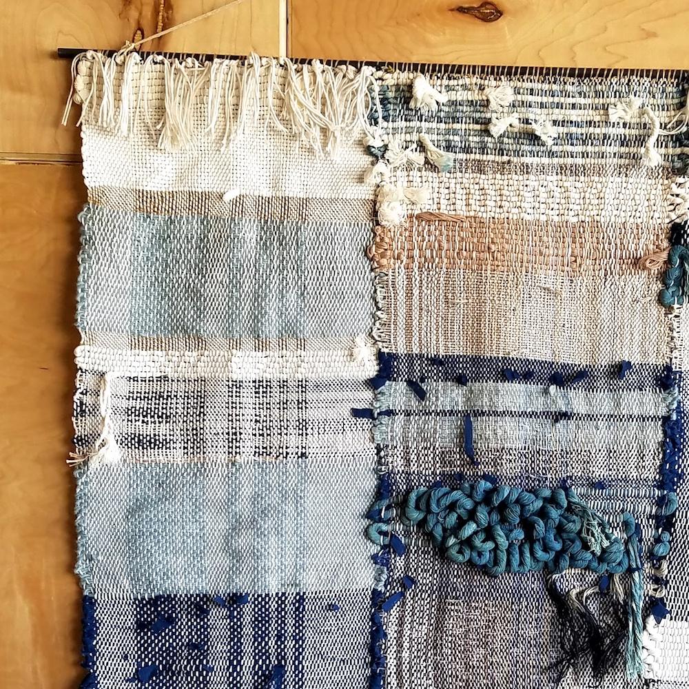 Hand woven wall hanging by Janelle Pietrzak of All Roads. Shades of indigo, navy blue, cream and black. This piece is multiple woven panels hand stitched together to make 1 piece. 

Fibers used are cotton, linen and wool Weaving hangs from a steel