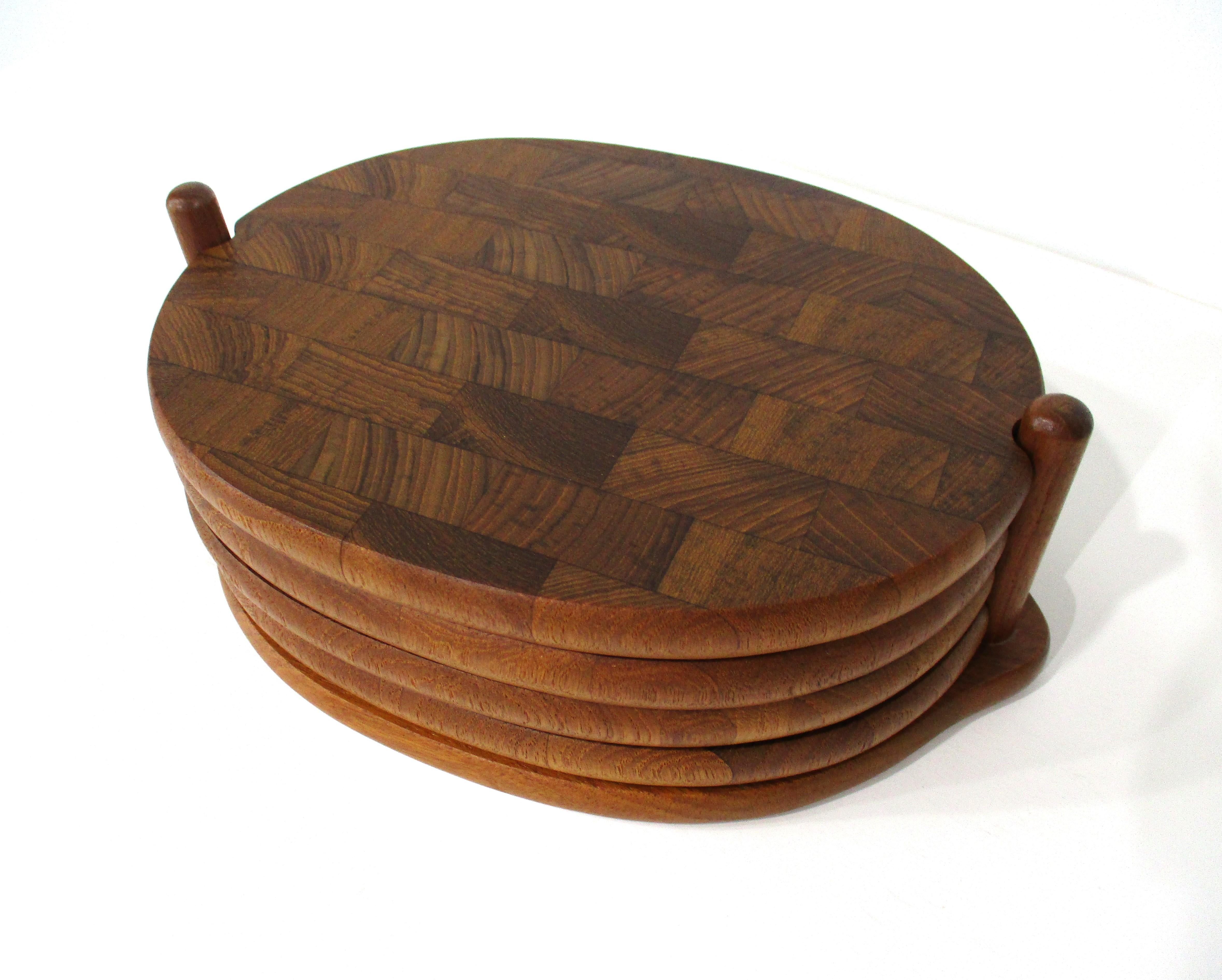 A set of four teakwood stacking individual serving / Charcuterie boards with matching holder . A great piece for that small get together or presenting your favorite cheeses and meats in style . Retains the branded mark and date of 1964 manufactured