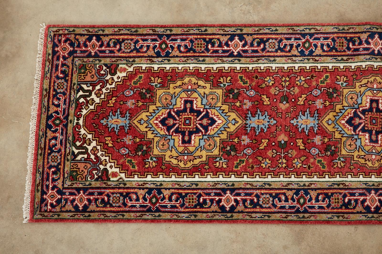 Vibrant and colorful Indo Persian runner with a Heriz Serapi style design. Made of hand-knotted wool with a thick soft pile. Interesting field garnet with a cream border. Deep moss green accents with light blue and pinks in the border over dark