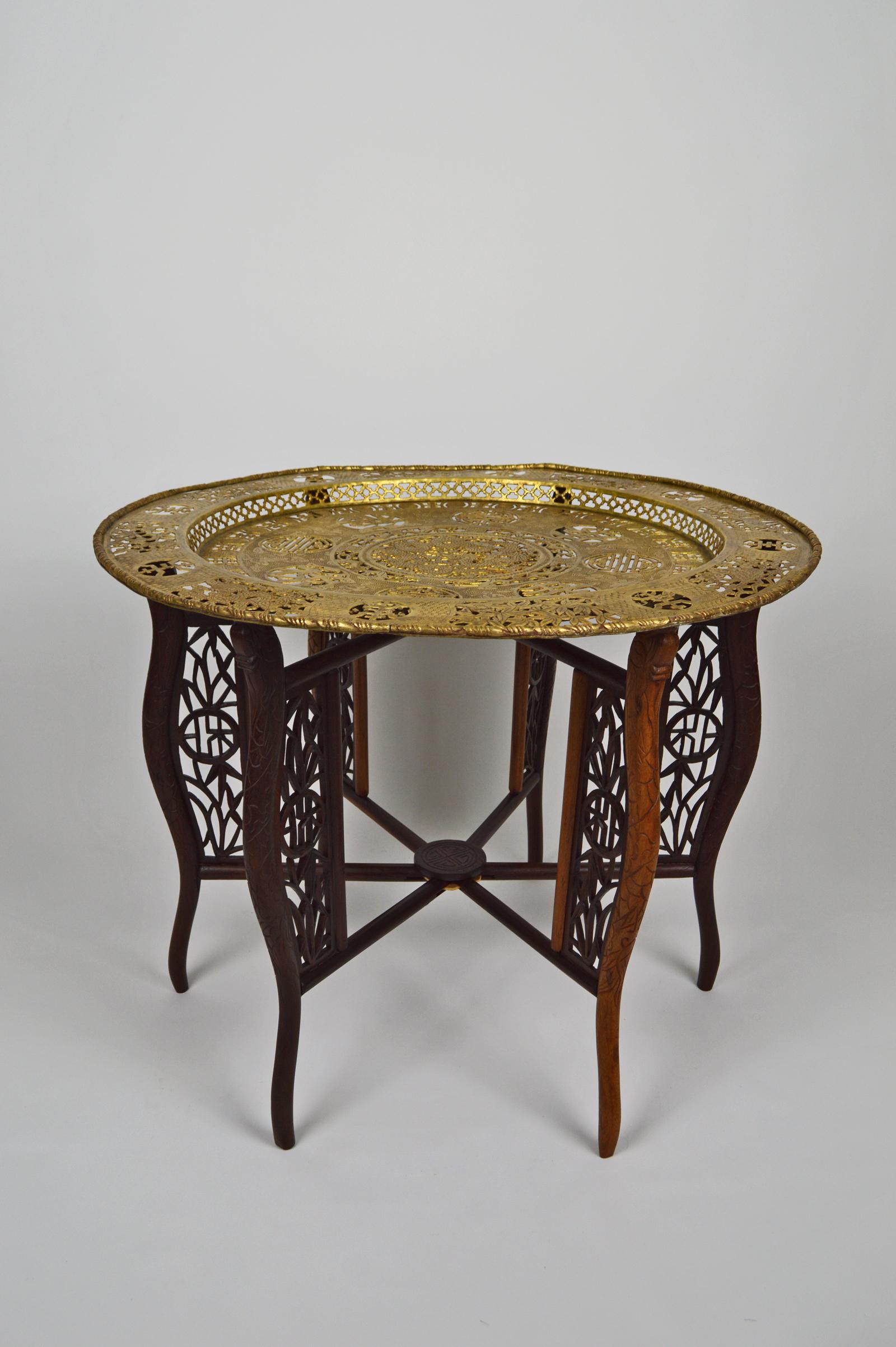 Wonderful tray table or tea or coffee table.

Folding base in carved solid wood, with dragons, bamboos and medallions or symbols.

Brass tray, with bronze patina. Richly decorated, with the eight immortals (The eight immortals are a group of